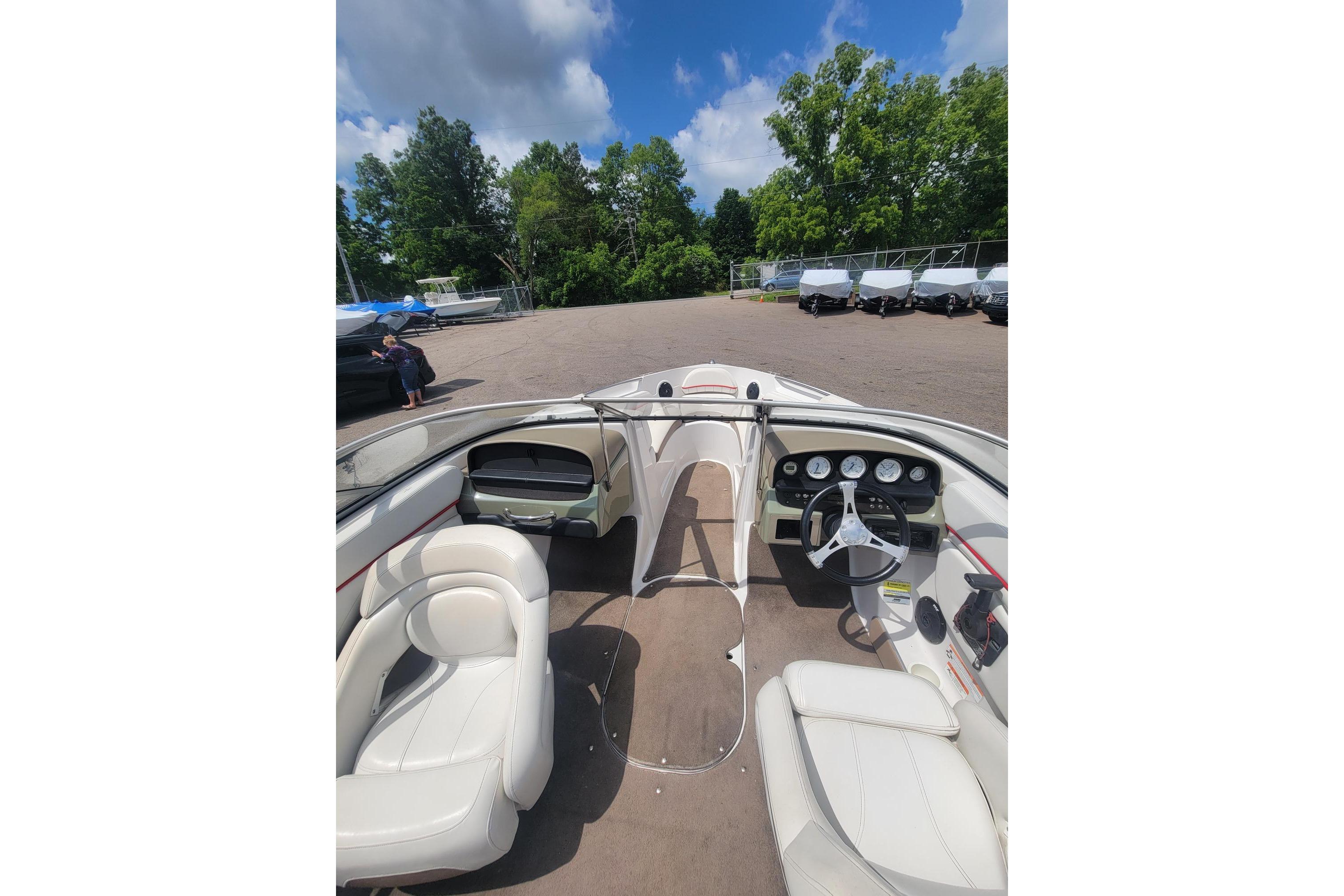 2007 Four Winns 200 Horizon boat interior with white seating and dashboard, parked outdoors.