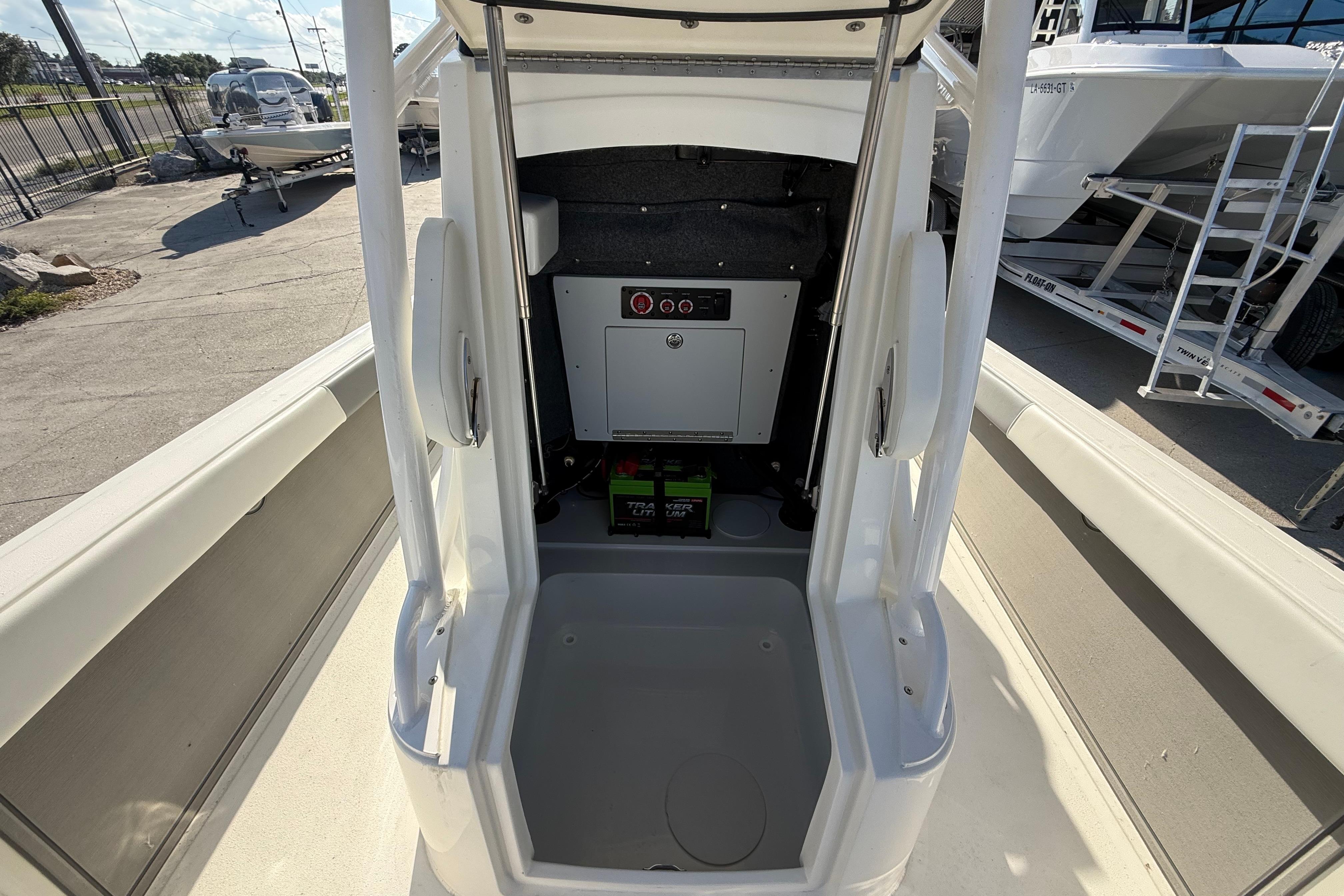 2026 Mako 24 APEX boat interior with storage compartment and battery setup.