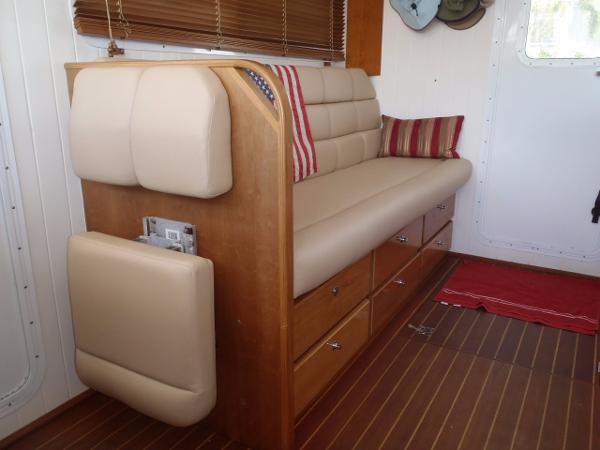 Interior of 2025 Great Harbour N40 yacht with beige seating and wooden storage drawers.