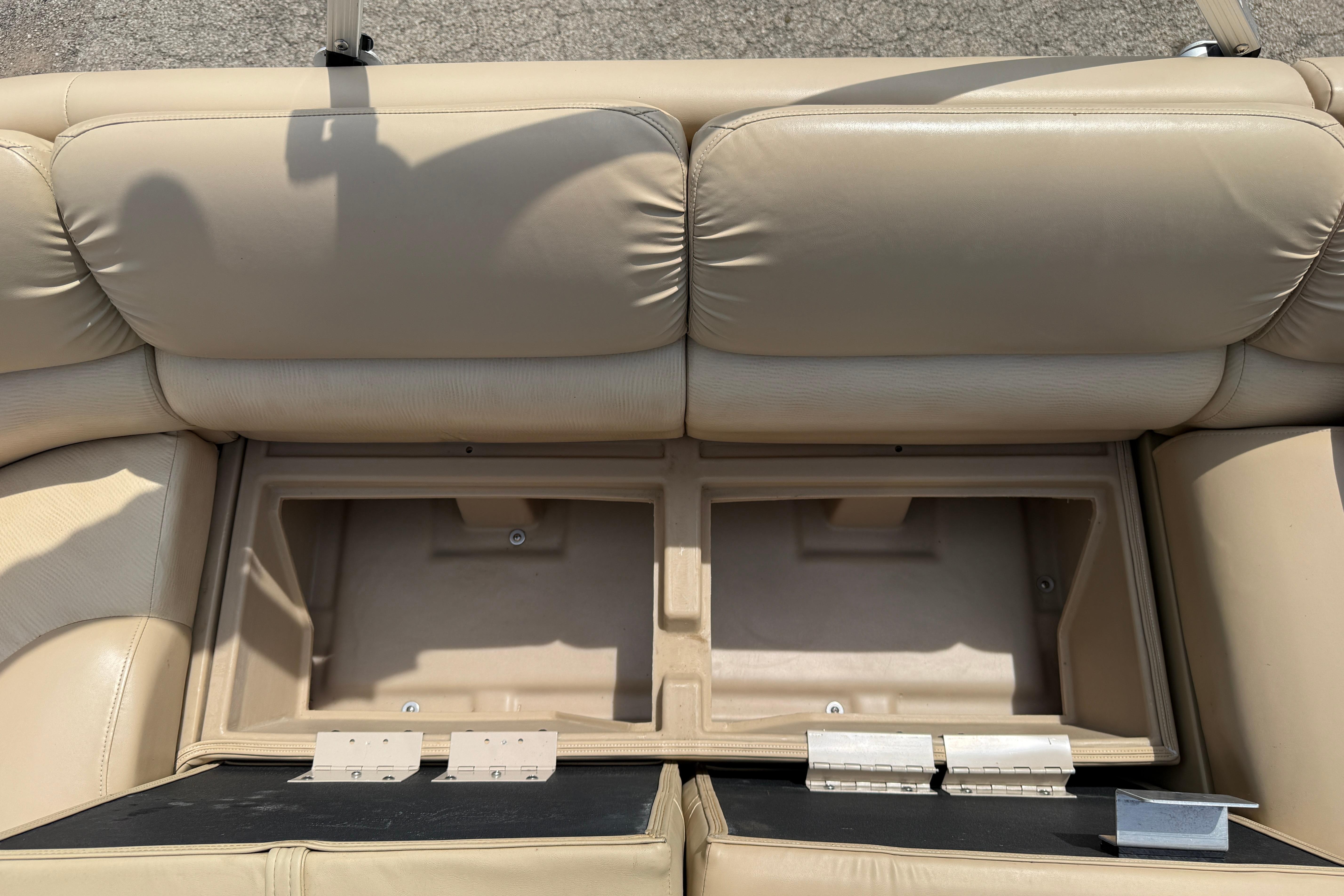 Open storage compartment in beige seating of 2011 Bennington 2575QCW I/O boat.