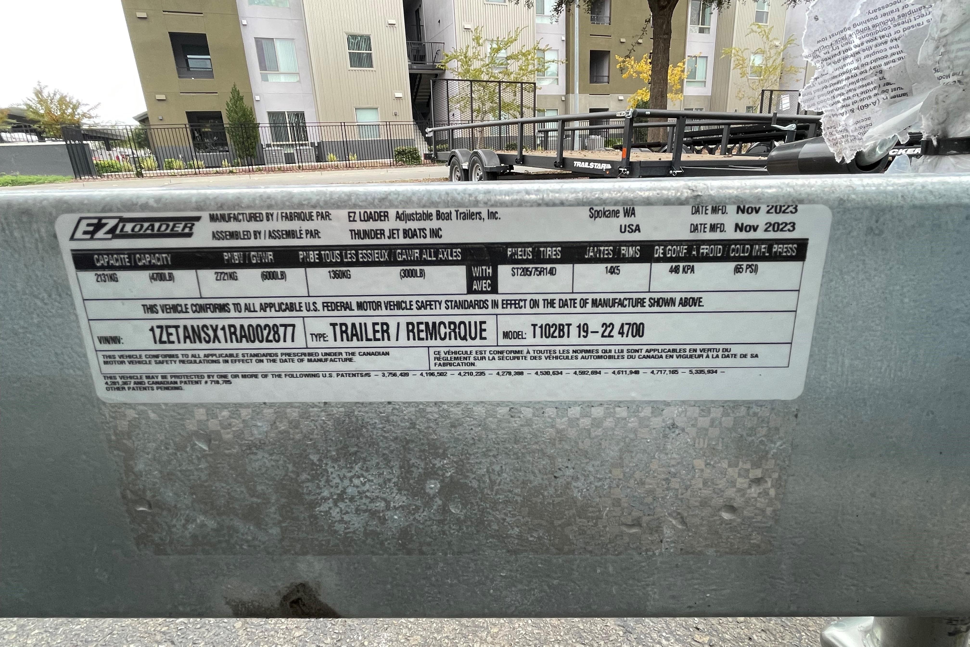 Label on EZ Loader trailer, manufactured November 2023, with specifications and compliance details.
