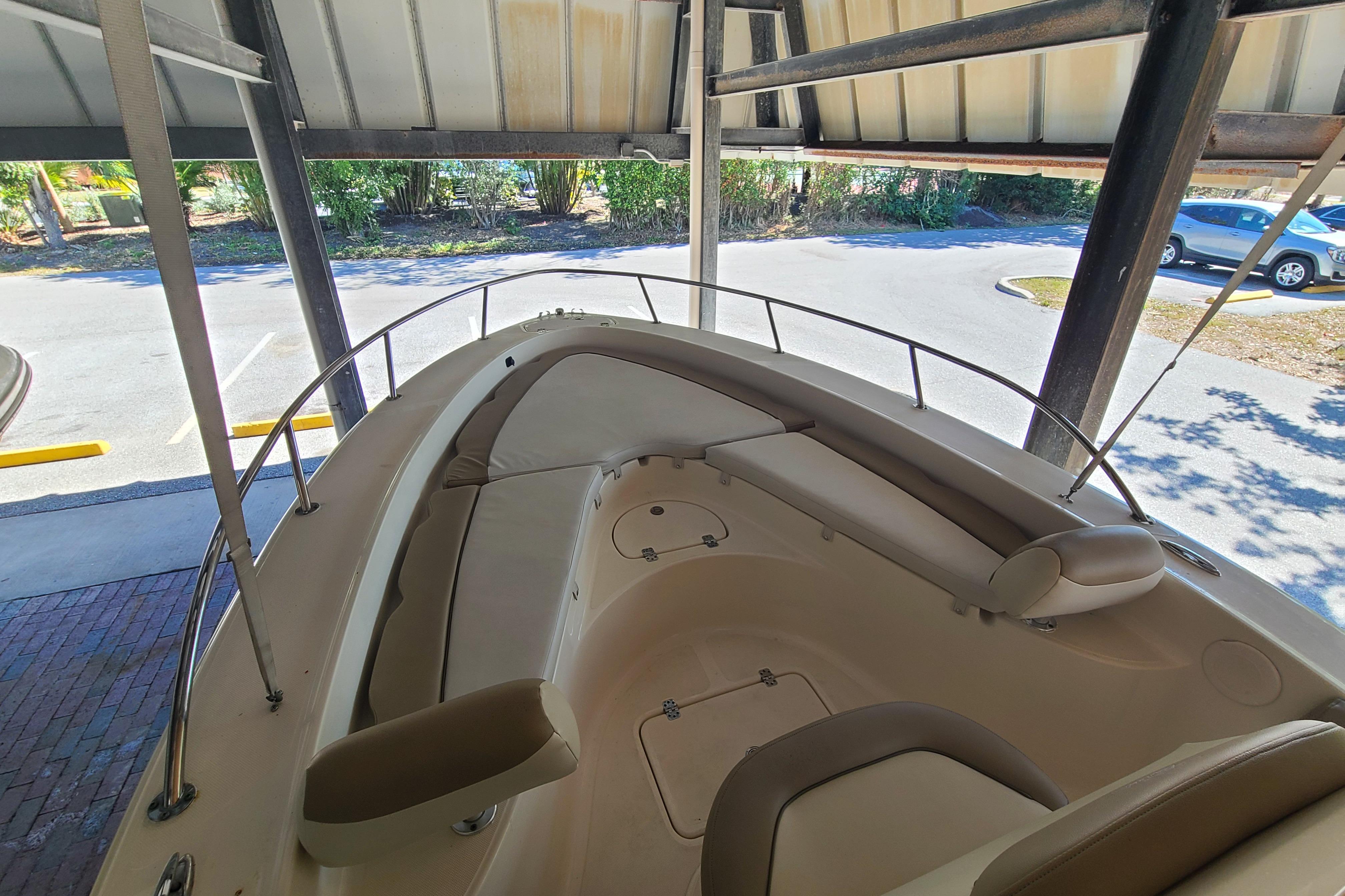 2015 Pioneer 220 Bay Sport boat interior under shelter, featuring cushioned seating.