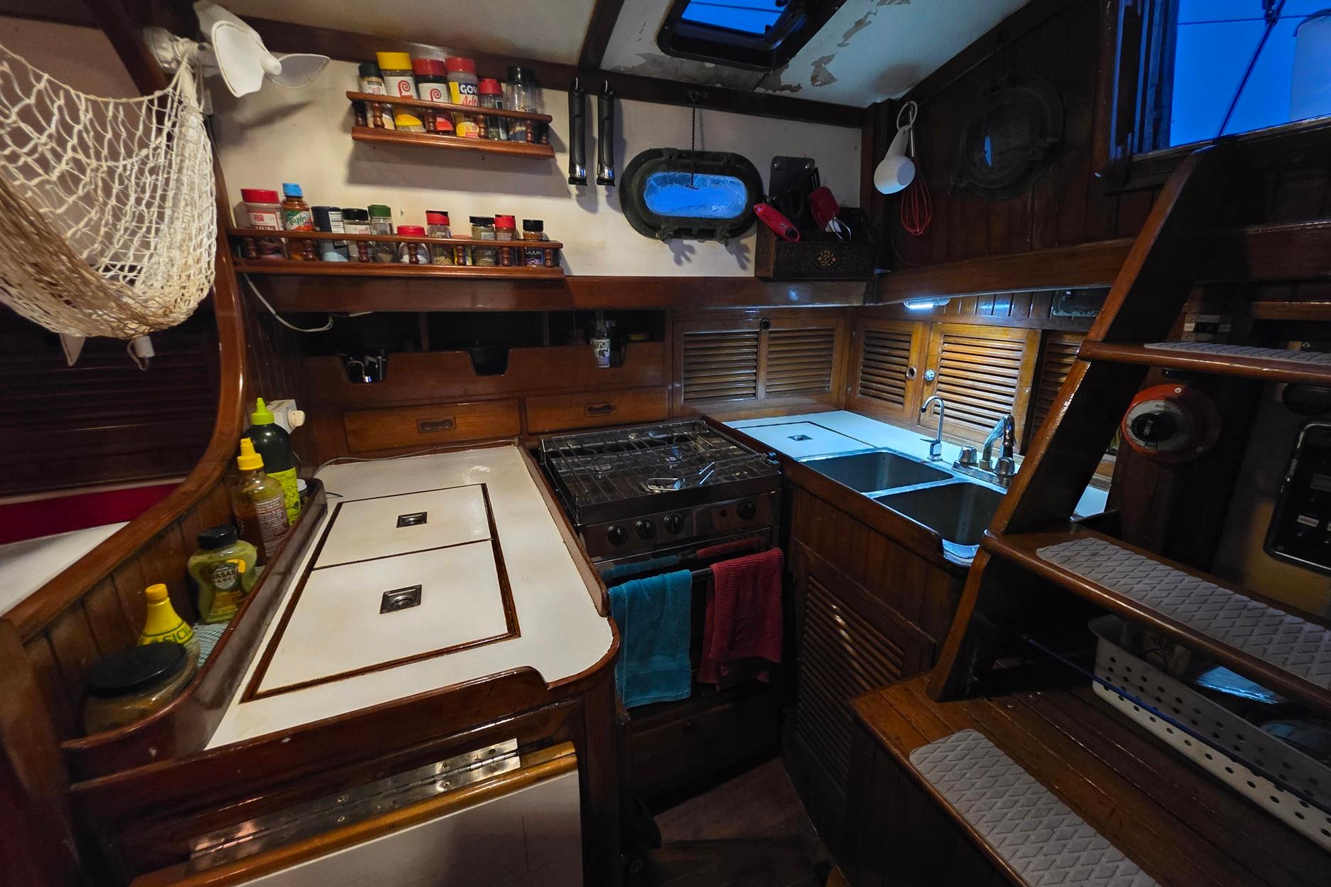 Cozy 1982 Tayana 37 yacht kitchen with wooden cabinetry and modern amenities.