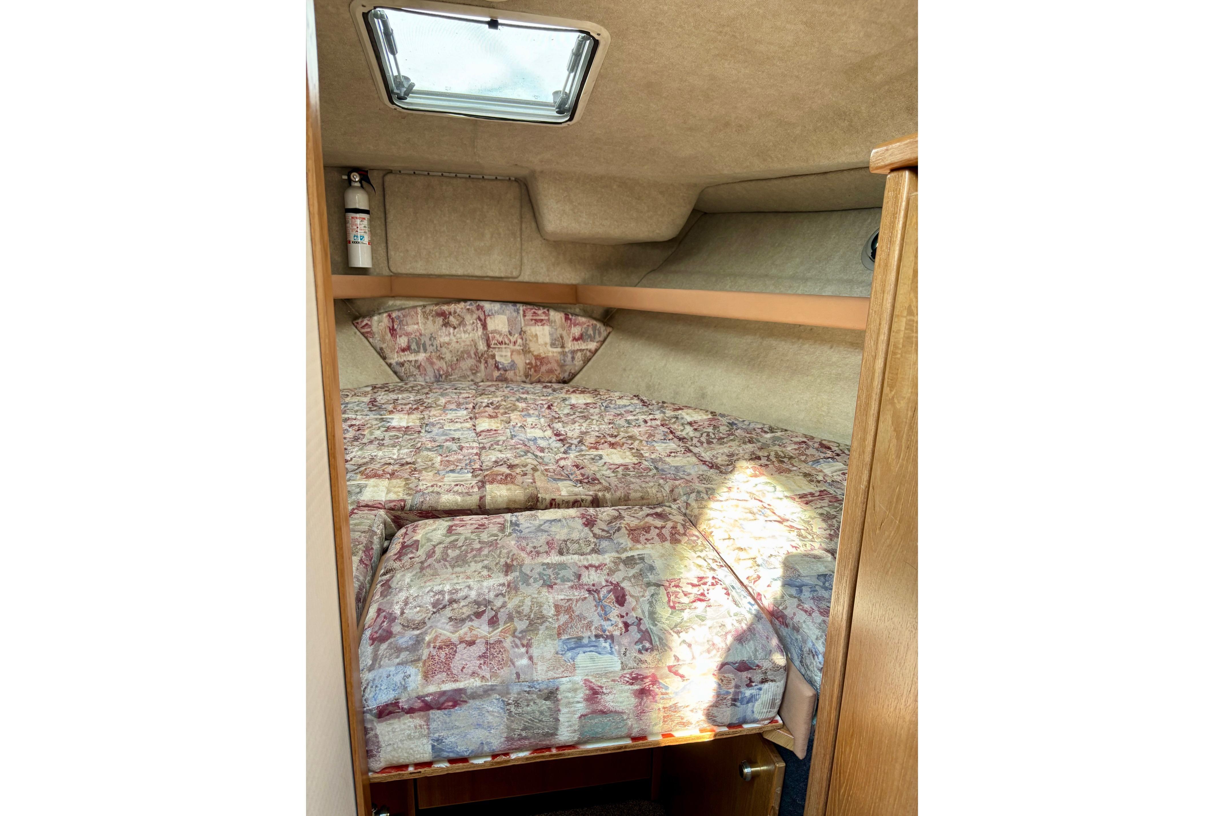 1998 Bayliner 3388 Command Bridge Motoryacht cabin with patterned bedding and overhead hatch.