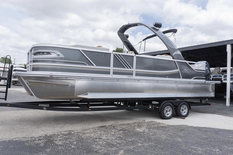 2026 SunCatcher Elite 326 SS pontoon boat on trailer, sleek design, parked outdoors.