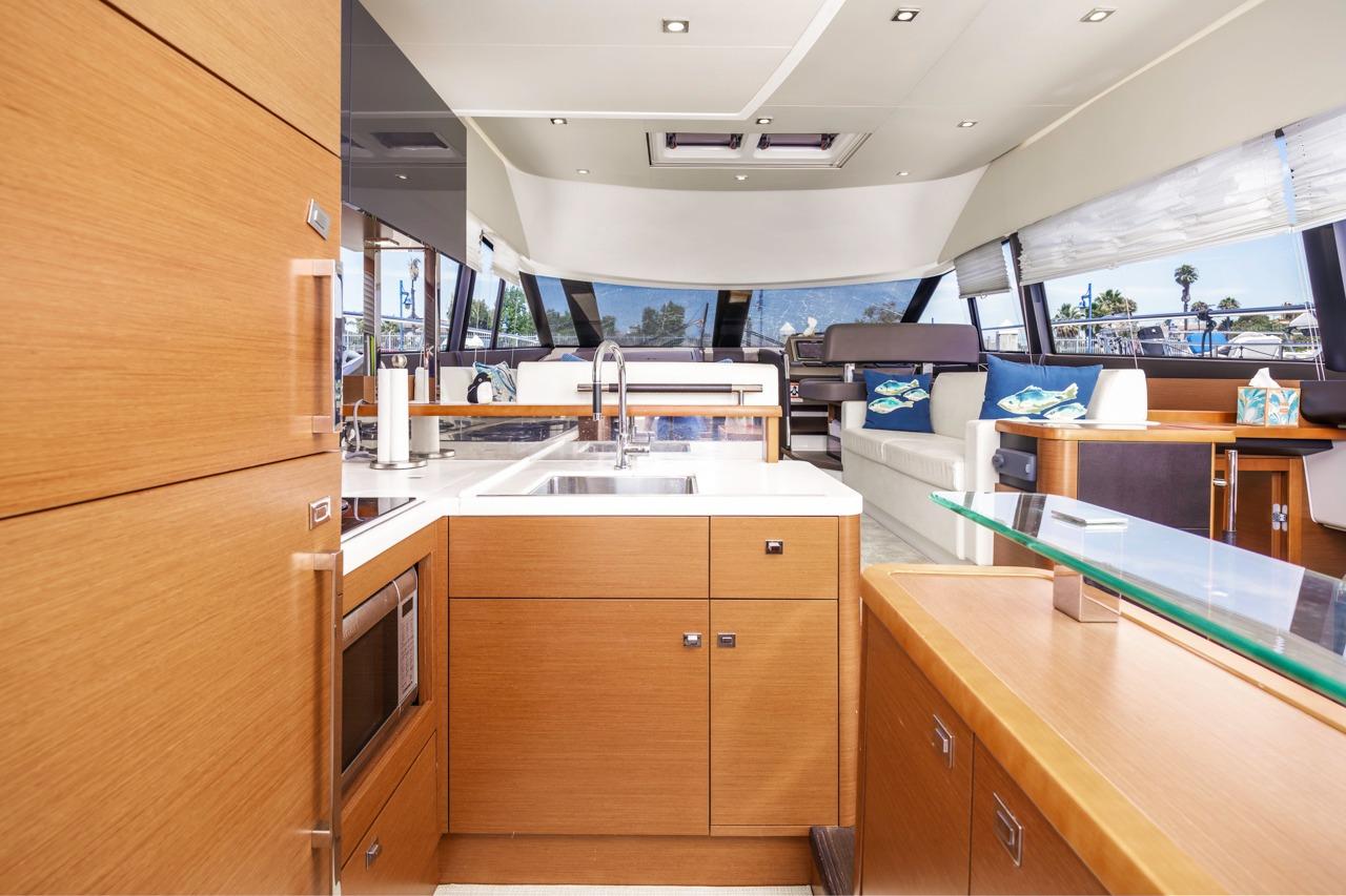 Luxurious interior of 2015 Prestige 500FB yacht with modern kitchen and spacious seating area.