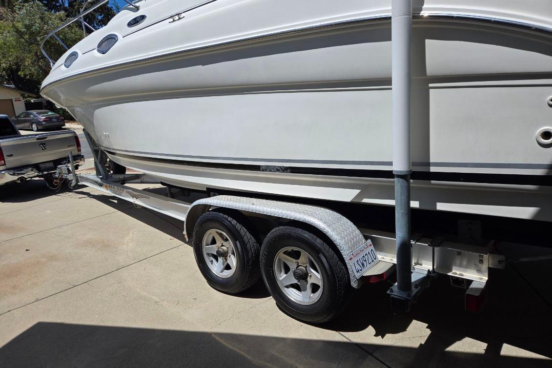 2004 Sea Ray Sundancer 260 boat on trailer, parked in driveway.
