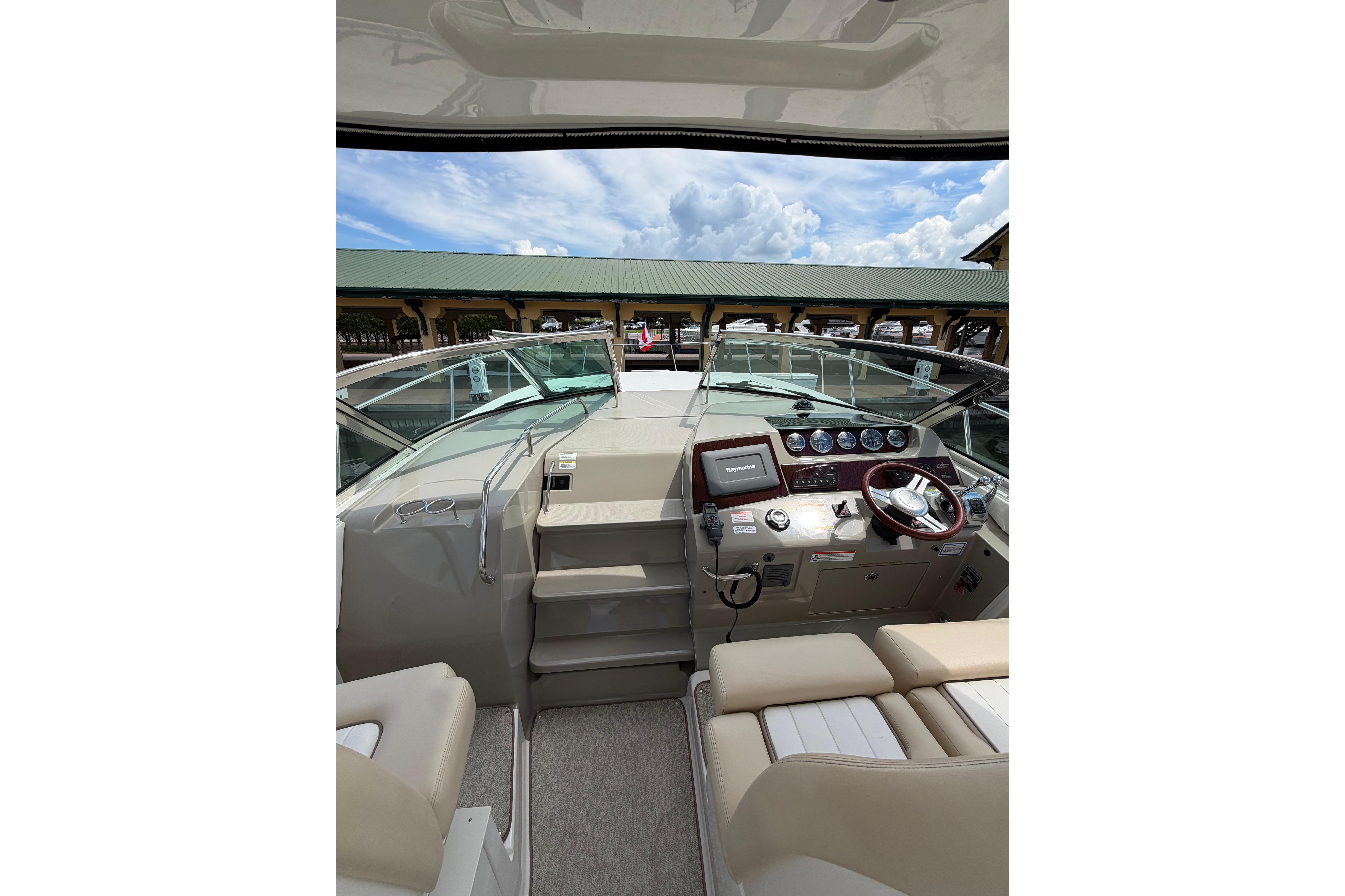 Interior view of 2012 Sea Ray Sundancer 370 boat cockpit with steering wheel and controls.