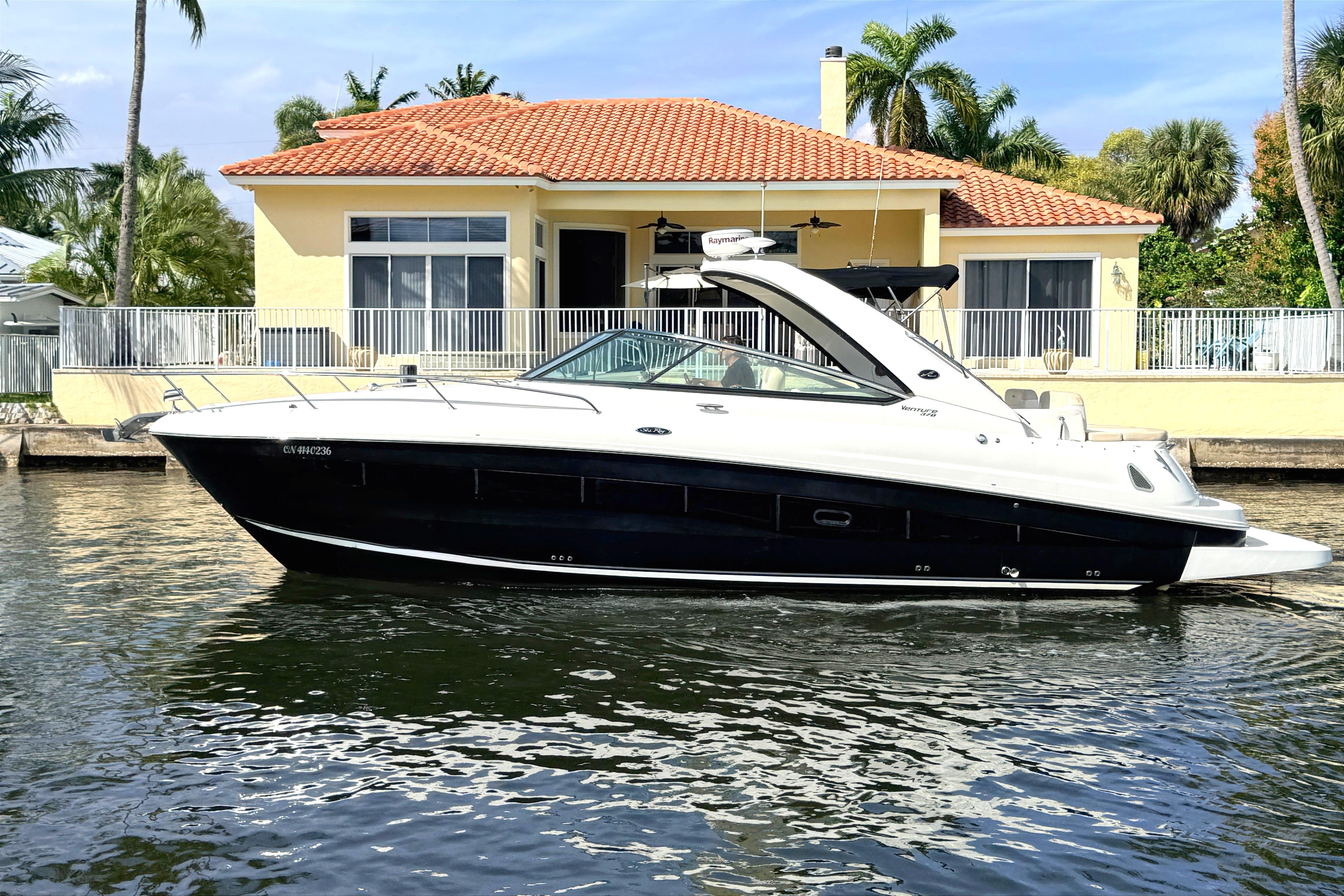 2013 Sea Ray 370 Venture yacht in front of waterfront house.