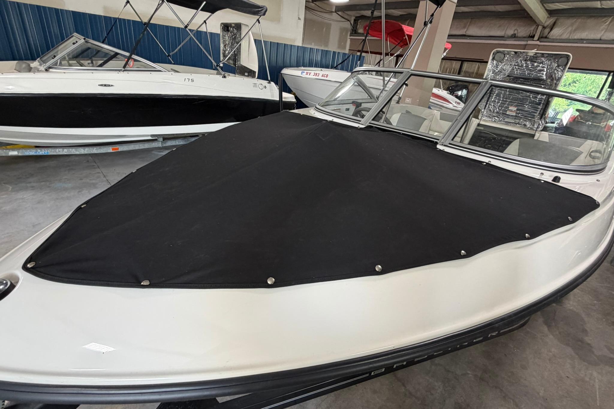 2012 Bayliner 175 Bowrider with black cover in a showroom setting.