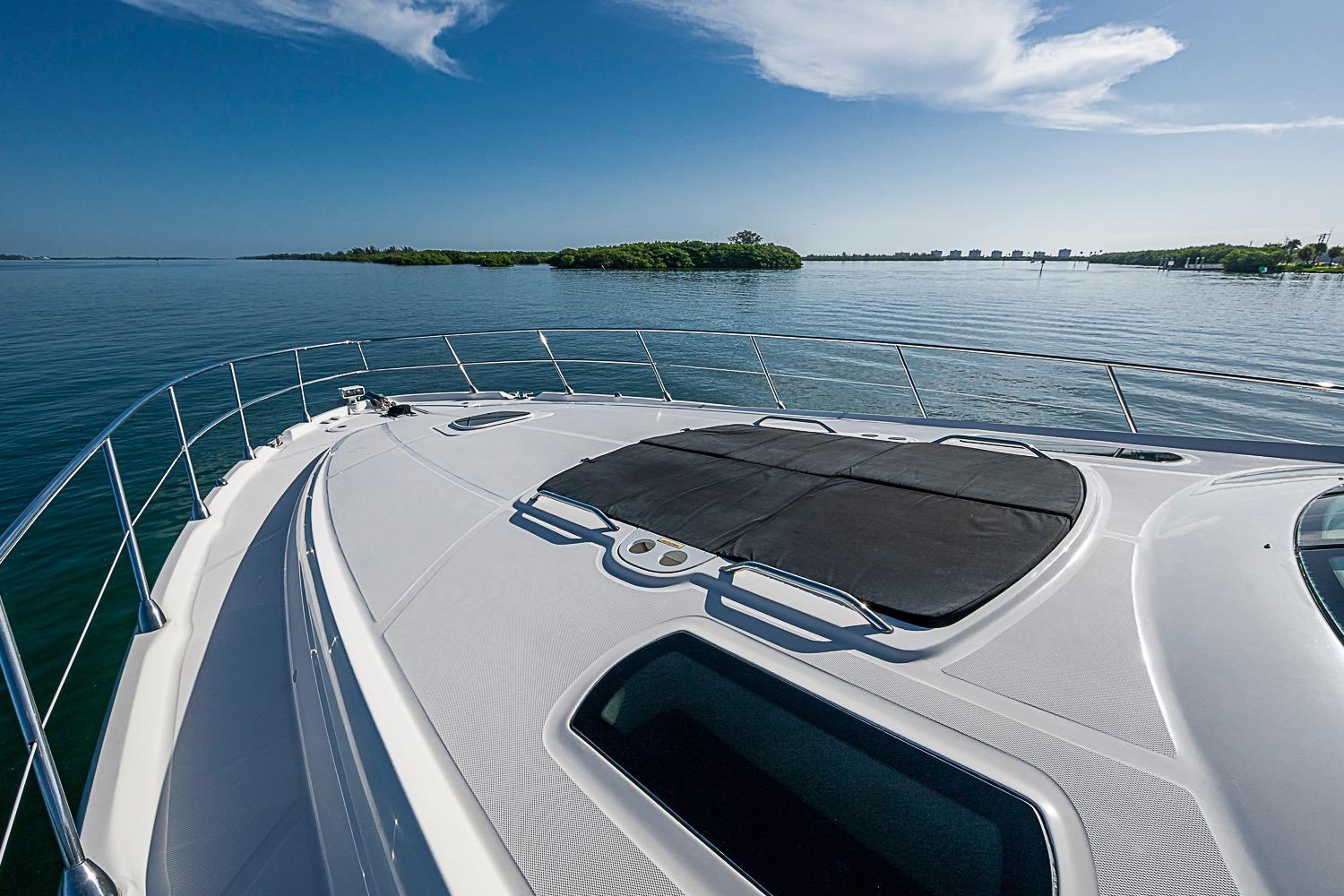 2008 Sea Ray 60 Sundancer yacht cruising on calm waters under a clear blue sky.