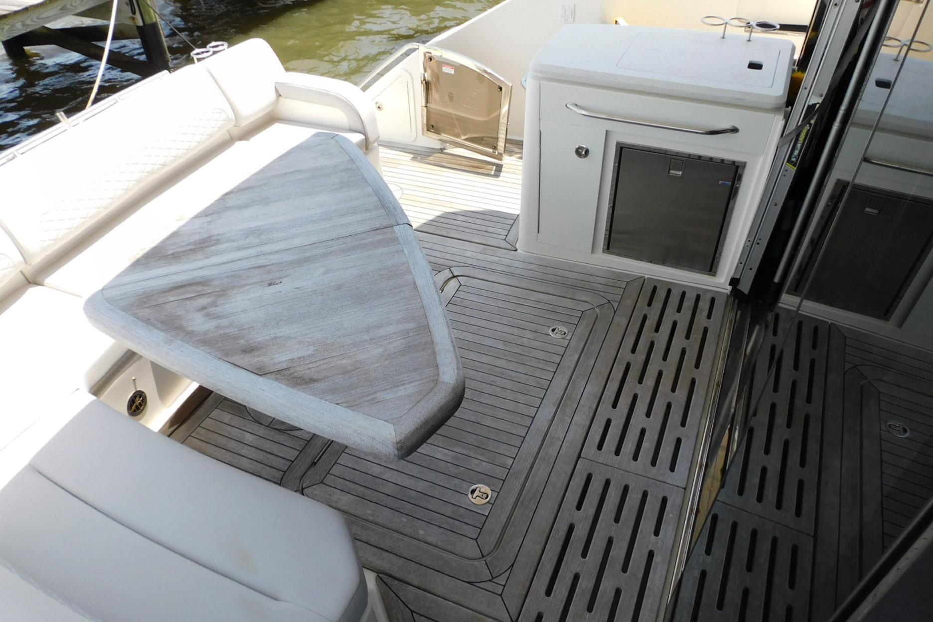Luxurious 2019 Sea Ray L550 yacht deck with elegant seating and wooden table.