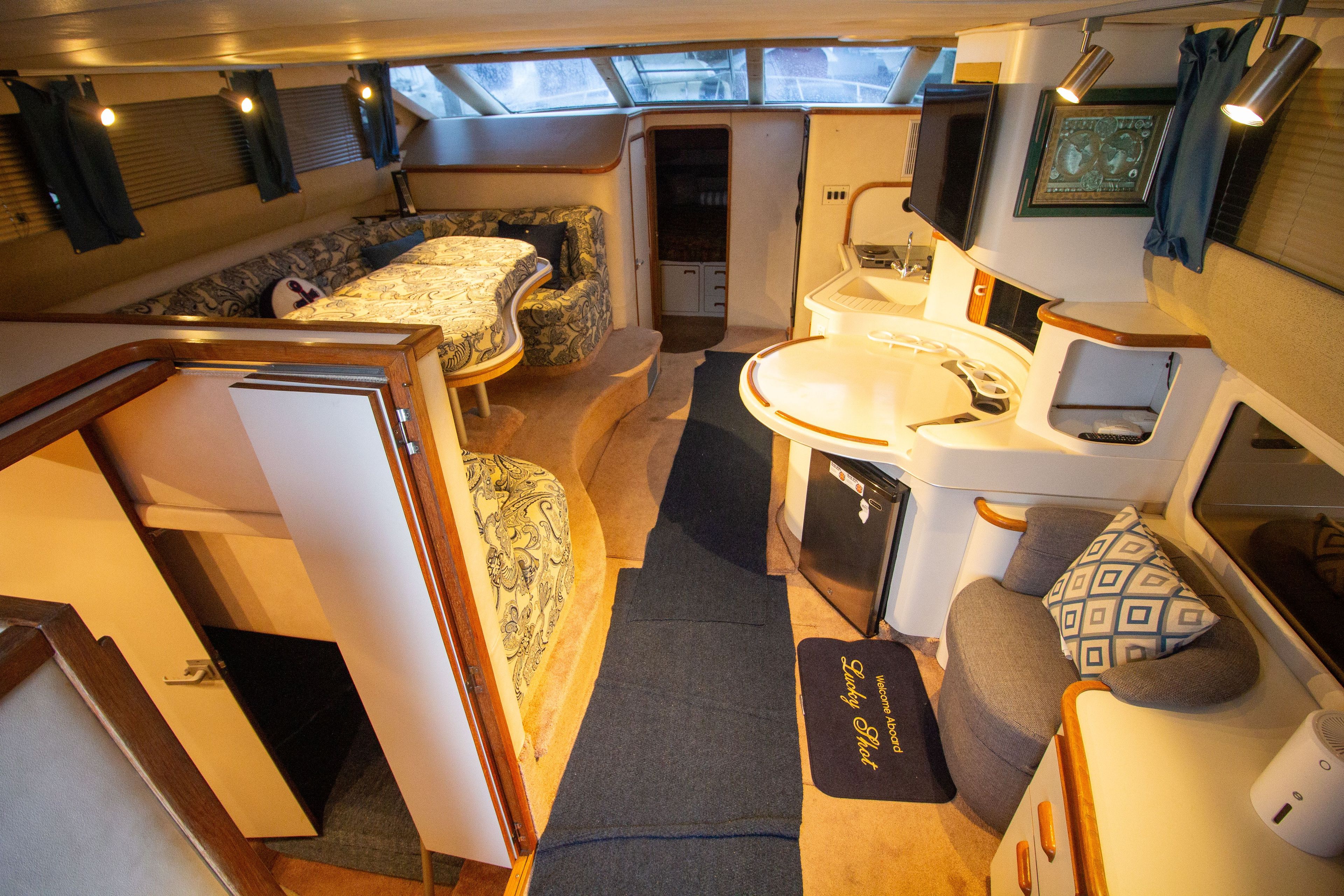 Interior of 1993 Sea Ray 440 Express Bridge, featuring cozy seating and kitchenette.