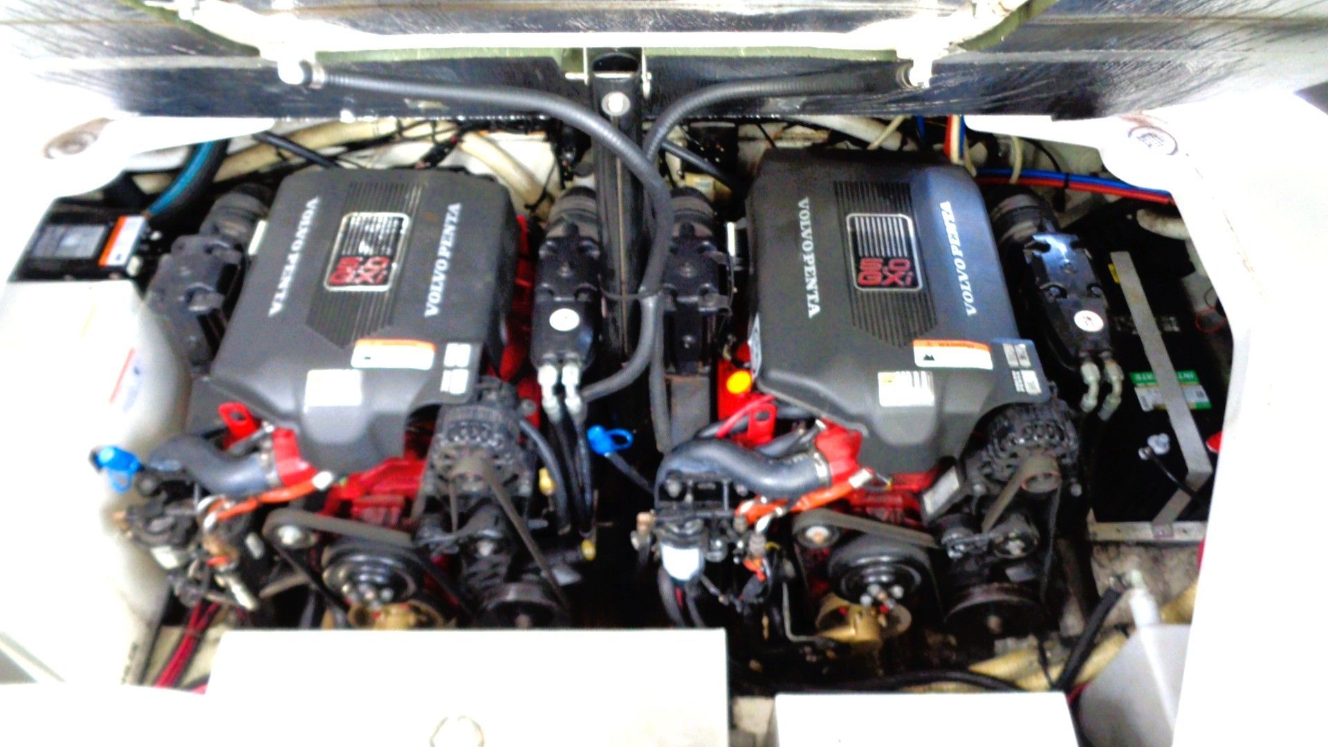 Two Volvo Penta engines in a boat's engine compartment, surrounded by cables and hoses.