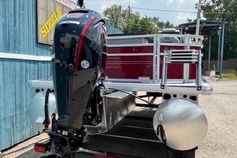 2026 Sun Tracker SportFish 20 DLX pontoon boat with powerful outboard motor, parked outdoors.
