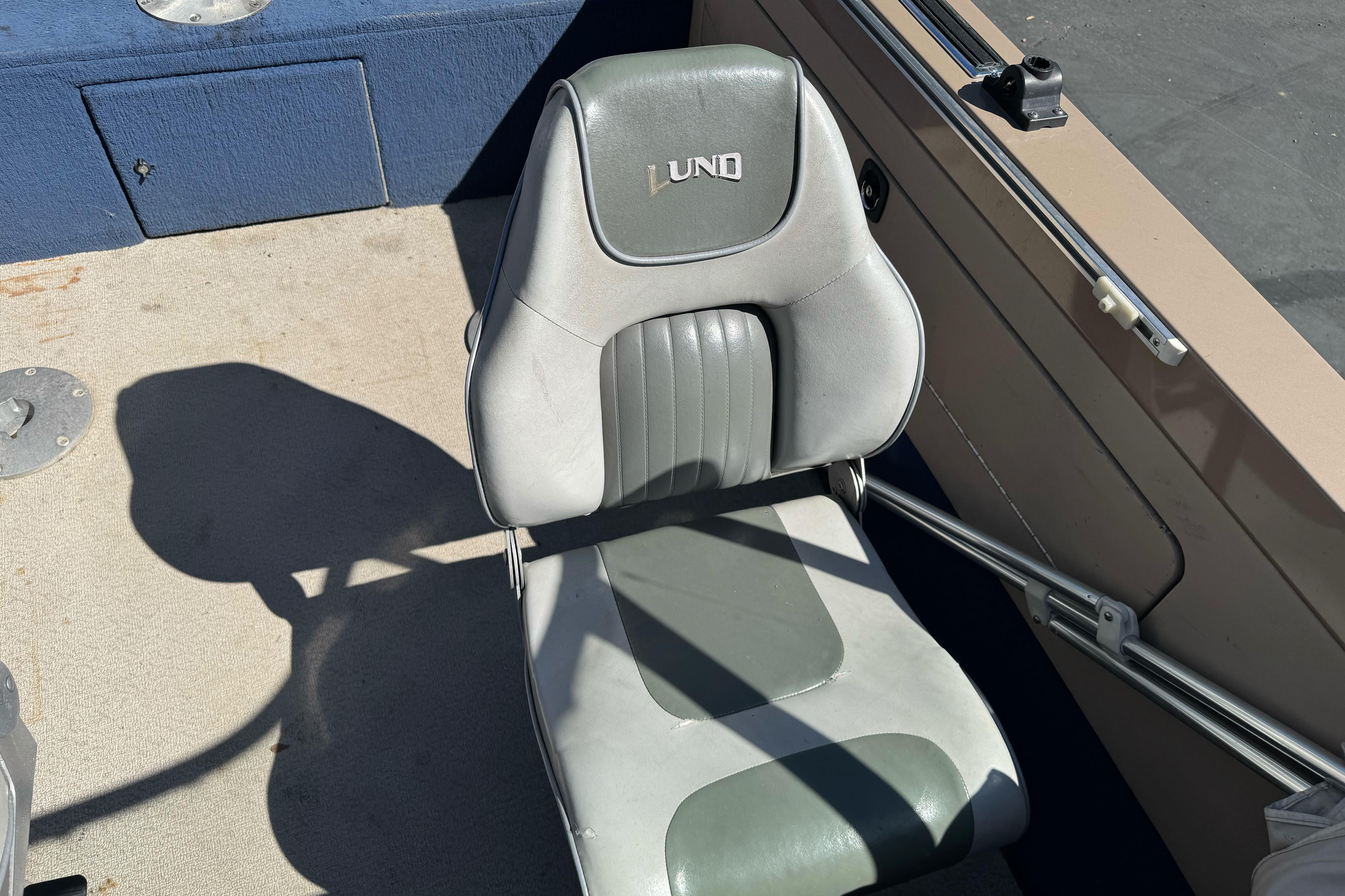 Lund 1700 Pro Sport 1998 boat seat with gray upholstery and logo.