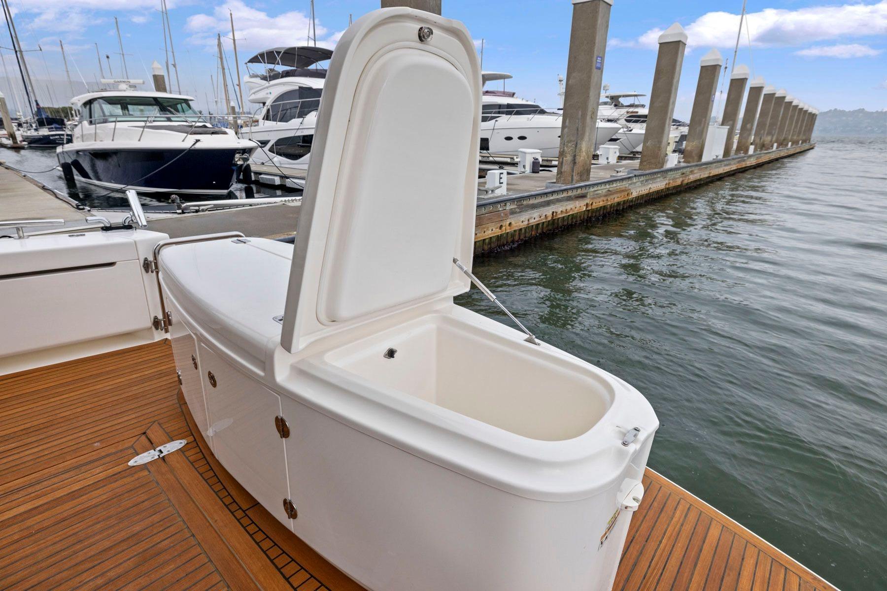 Open storage compartment on 2014 Maritimo M50 yacht docked at marina.