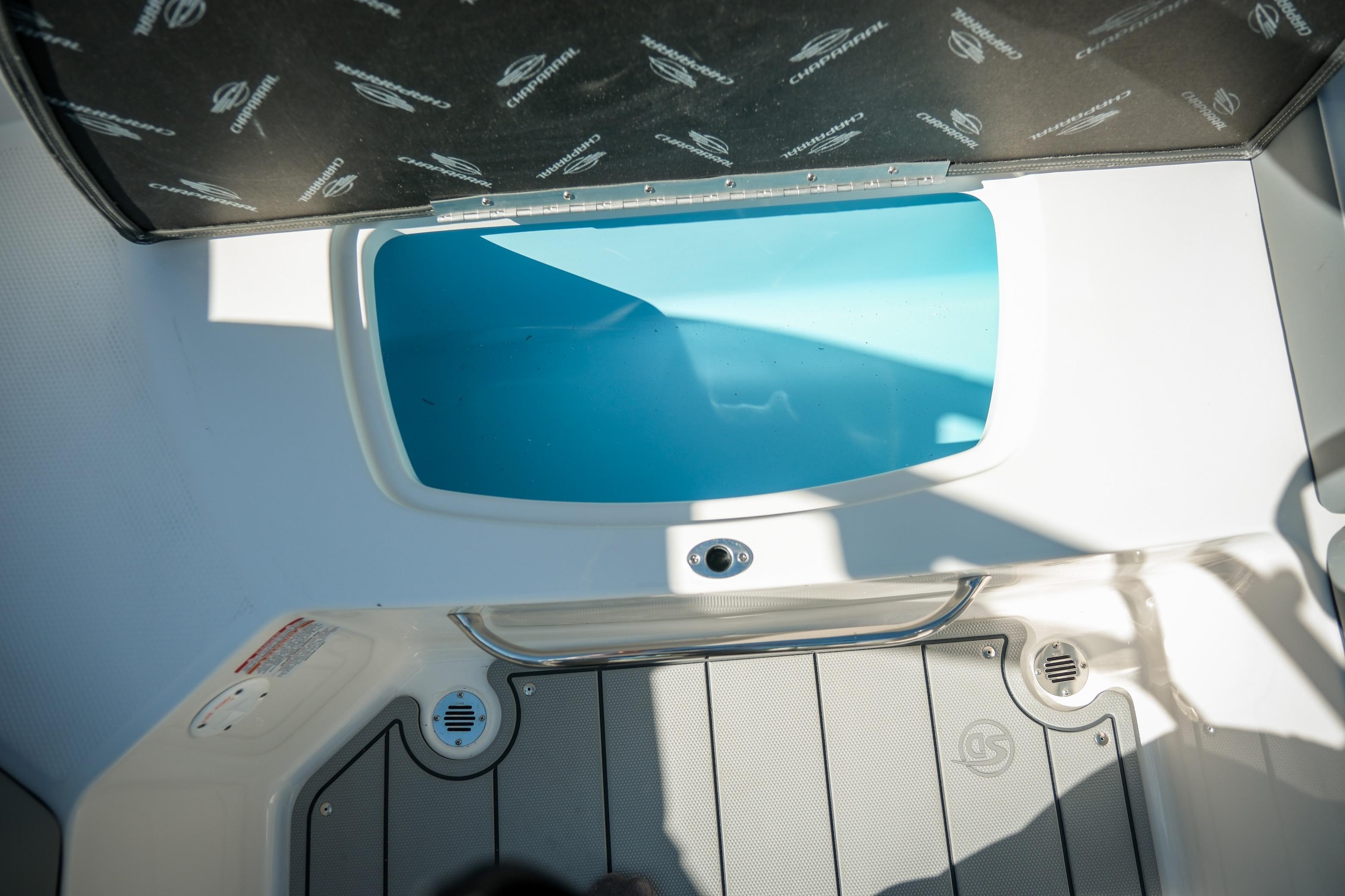 2026 Chaparral 23 SSi boat interior with open storage compartment.