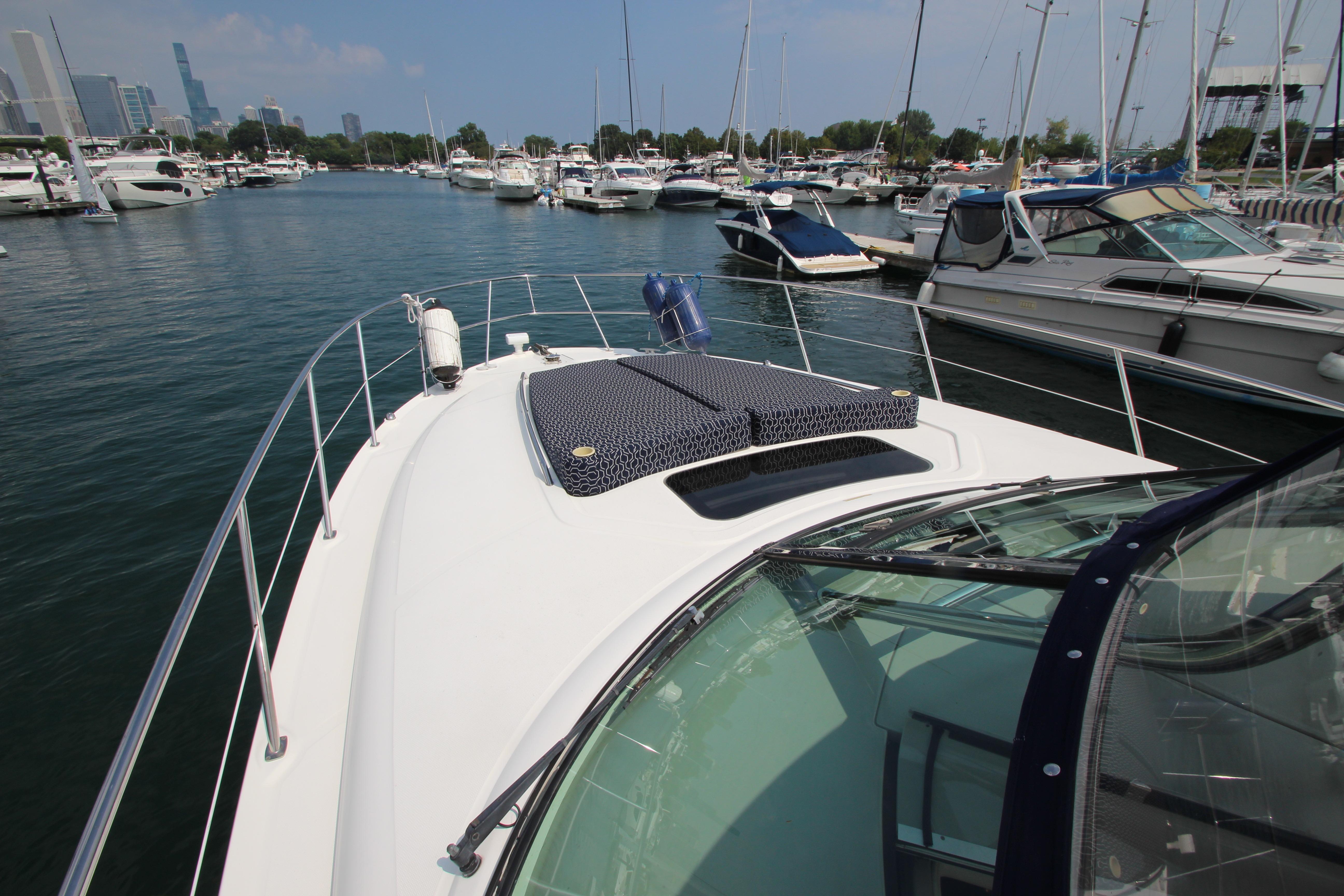 2004 Sea Ray 40 Sundancer yacht docked in a marina with city skyline.