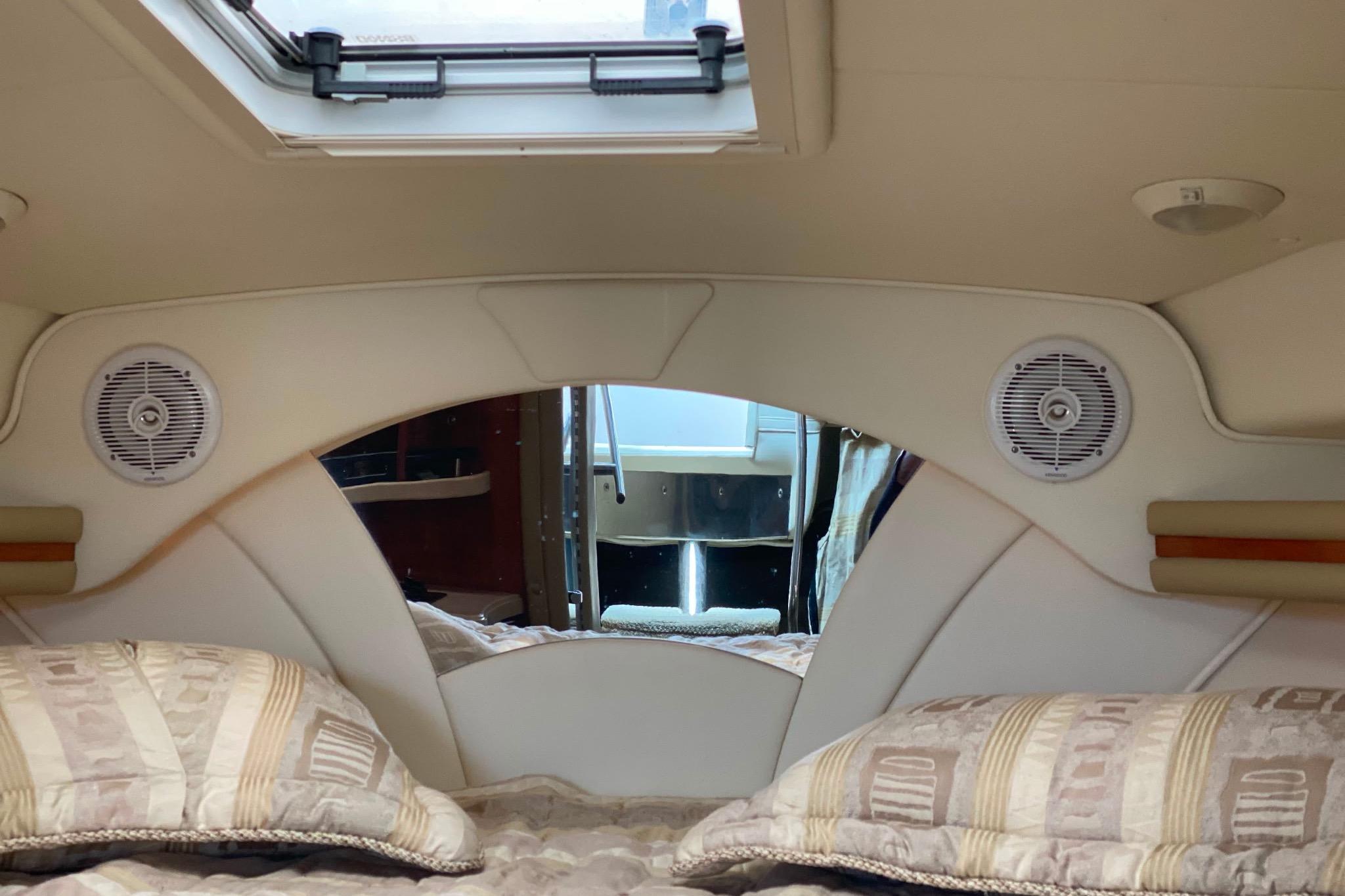 Interior cabin of 2003 Rinker Fiesta Vee 342 with bedding and speakers.