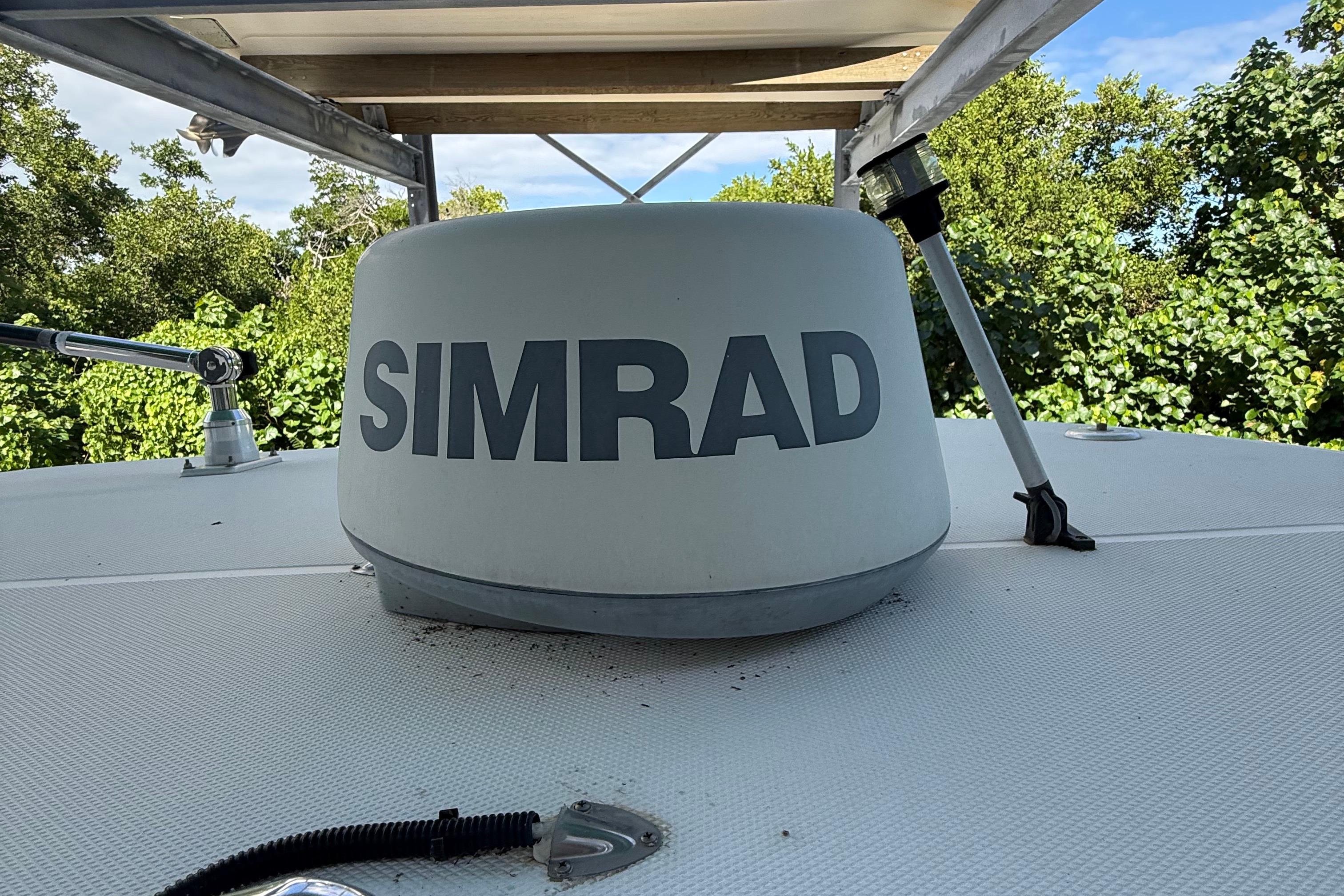 Simrad radar on 2008 Century 2901 Center Console boat, surrounded by greenery.