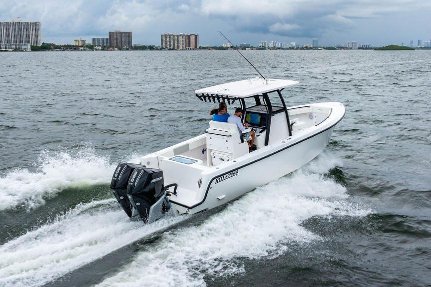 2027 Reef Runner 280 boat cruising on open water with city skyline in background.