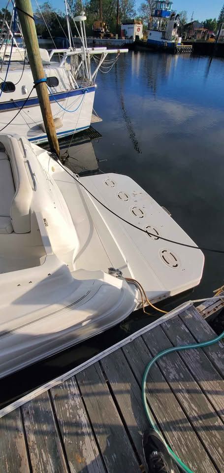 A 2002 Wellcraft 3300 Martinique is docked. The boat features a spacious deck.