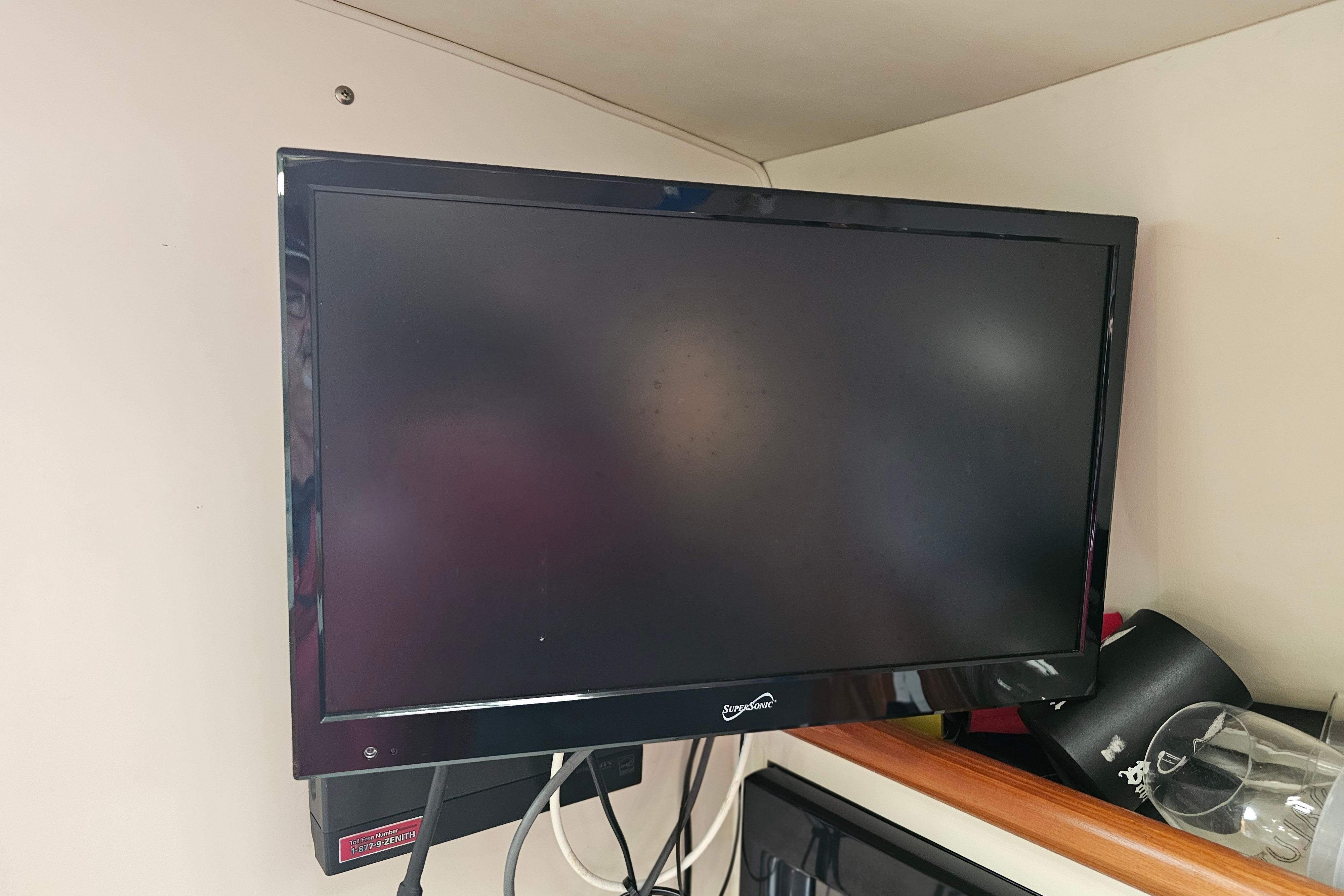 Wall-mounted TV inside 2001 Pursuit 3000 Express boat cabin.
