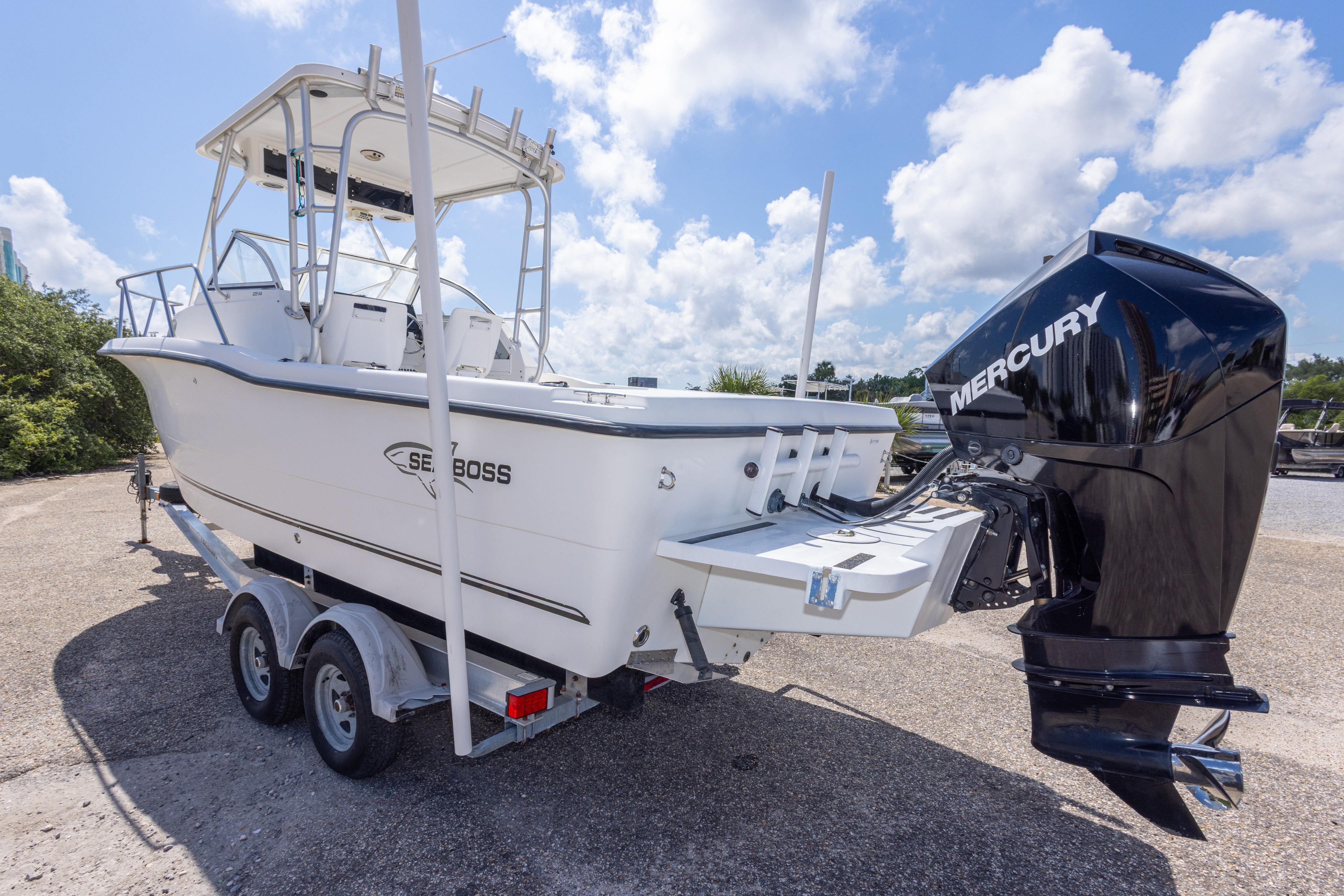 2007 Sea Boss 235 Walkaround boat with Mercury engine on trailer, under a clear sky.