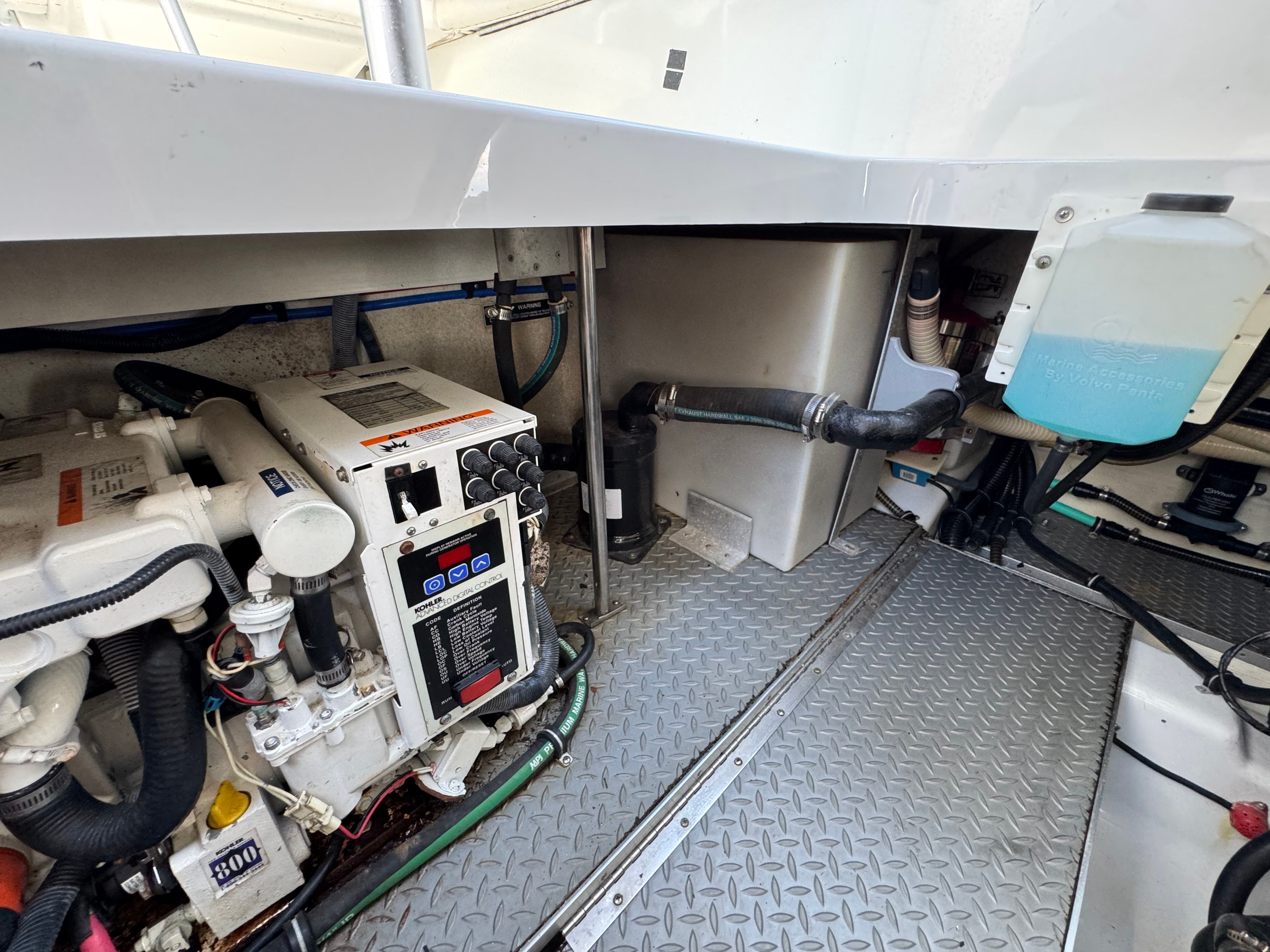 The engine compartment of a boat with machinery and pipes.