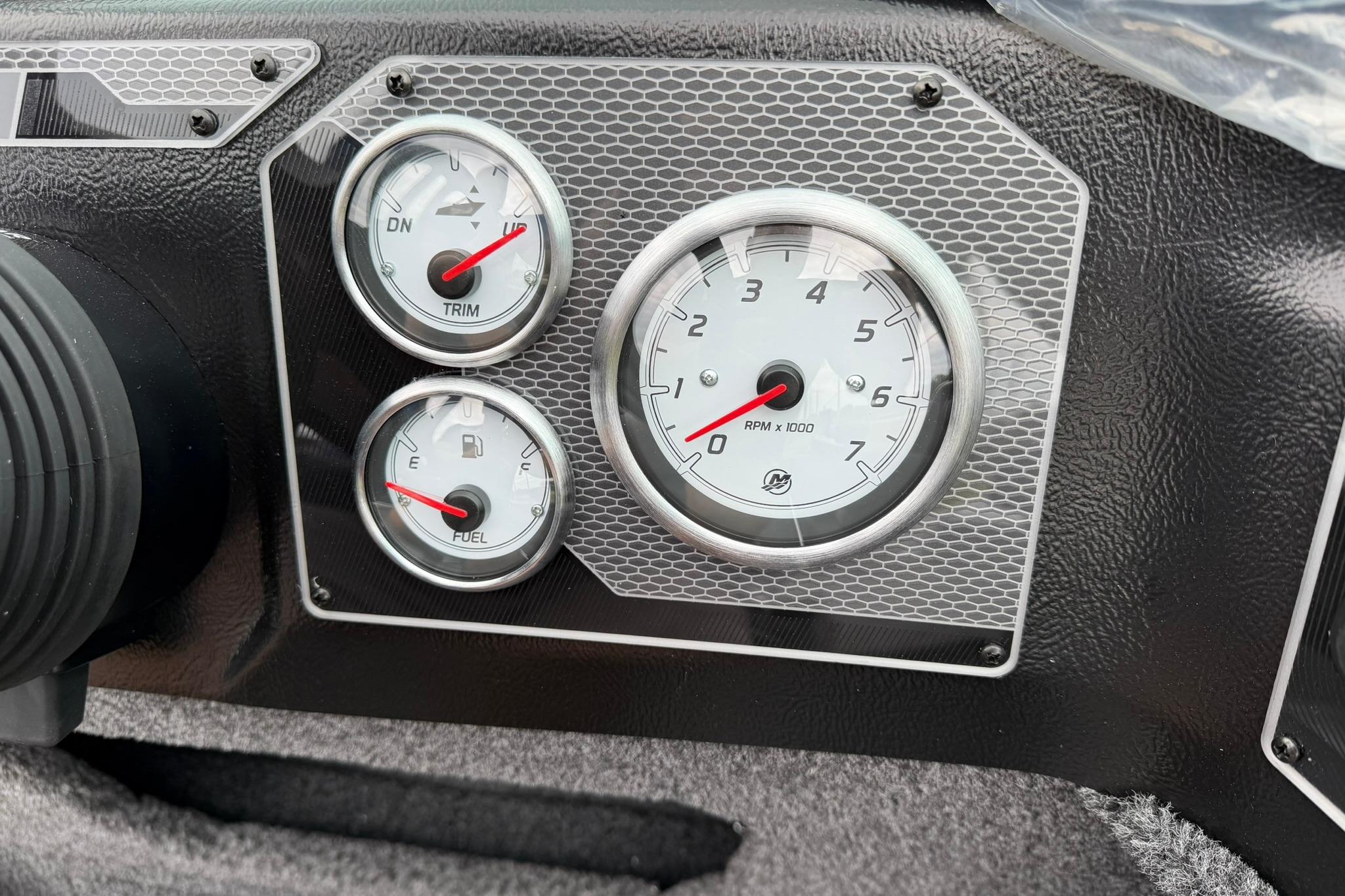 Dashboard of 2027 Lund 1875 Impact XS Sport boat with RPM, trim, and fuel gauges.