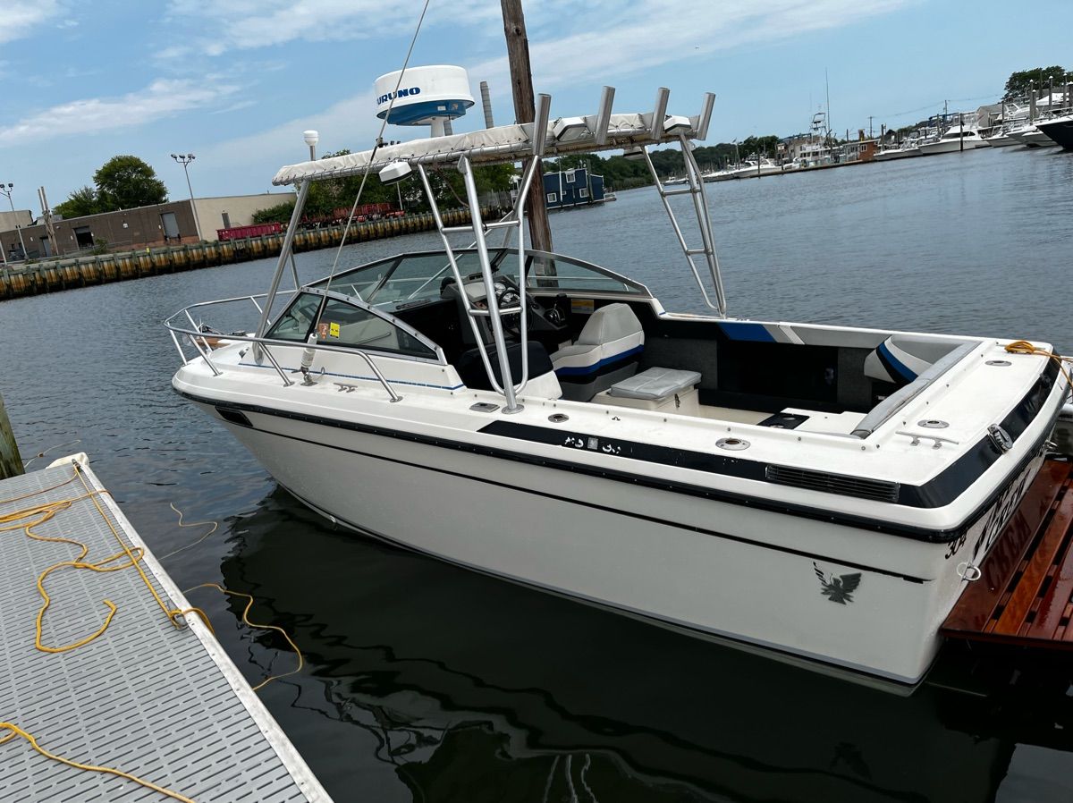 1986 Formula 21 boat at dock with open cockpit and T-top.
