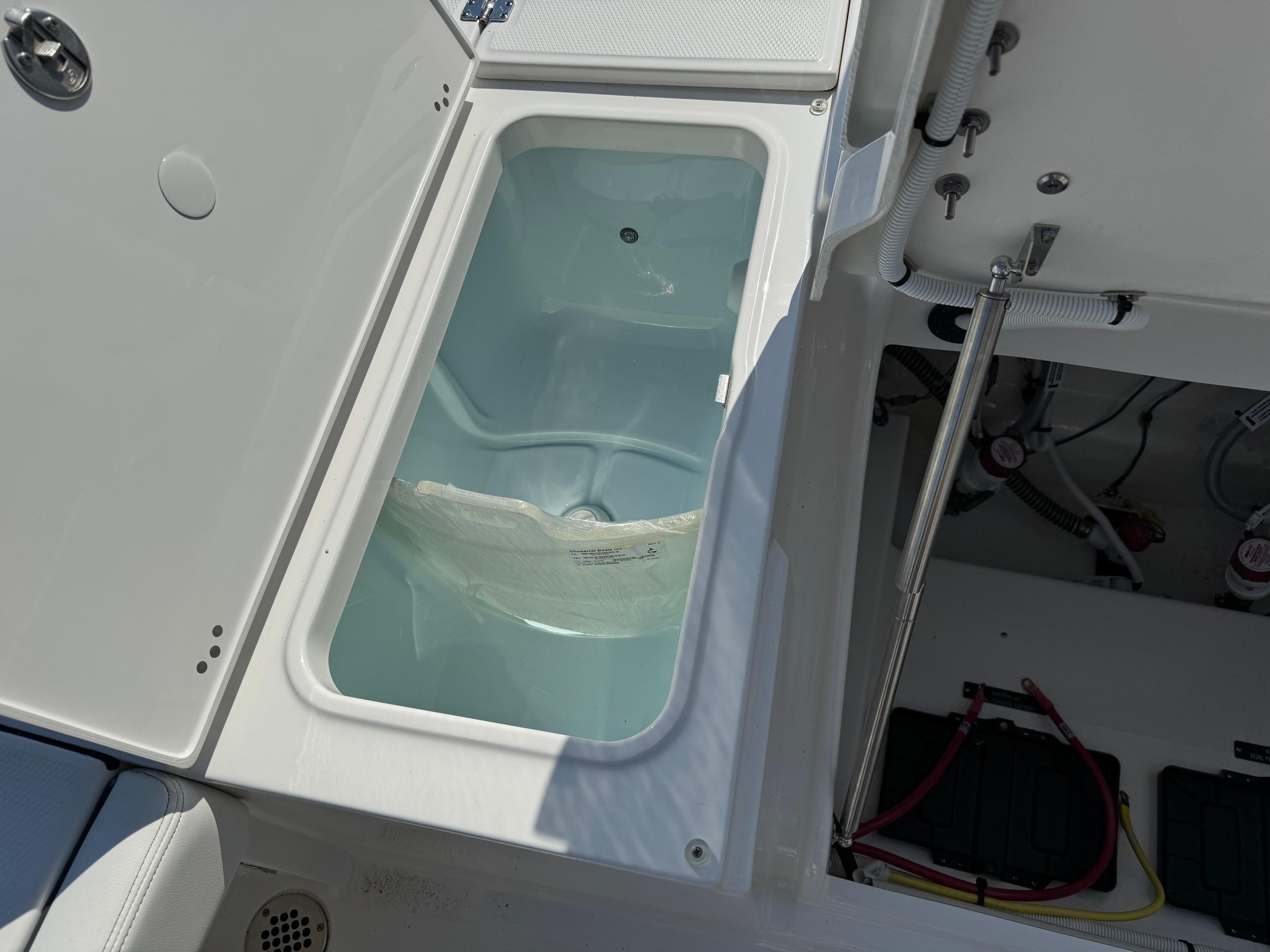 2025 Robalo R246 CAYMAN boat storage compartment with open hatch and visible wiring.
