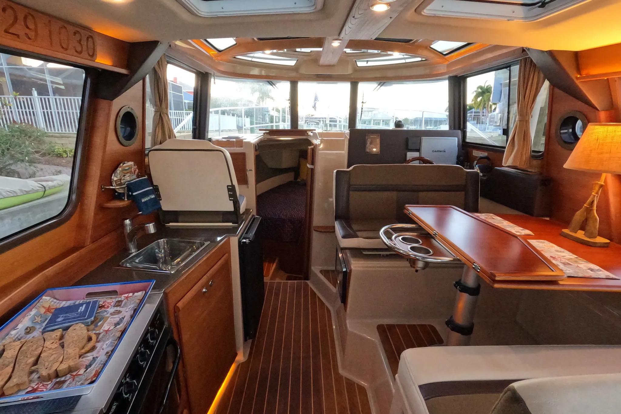 Interior of 2015 Ranger Tugs R-29 S, featuring cozy seating and a compact kitchen area.