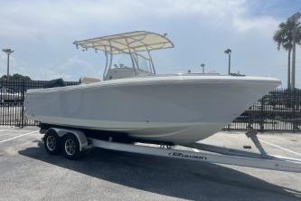 2023 Sailfish 242 CC boat on trailer, parked outdoors under a cloudy sky.