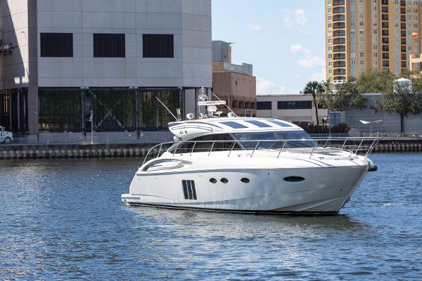 2013 Princess V57 luxury yacht on water with urban backdrop.