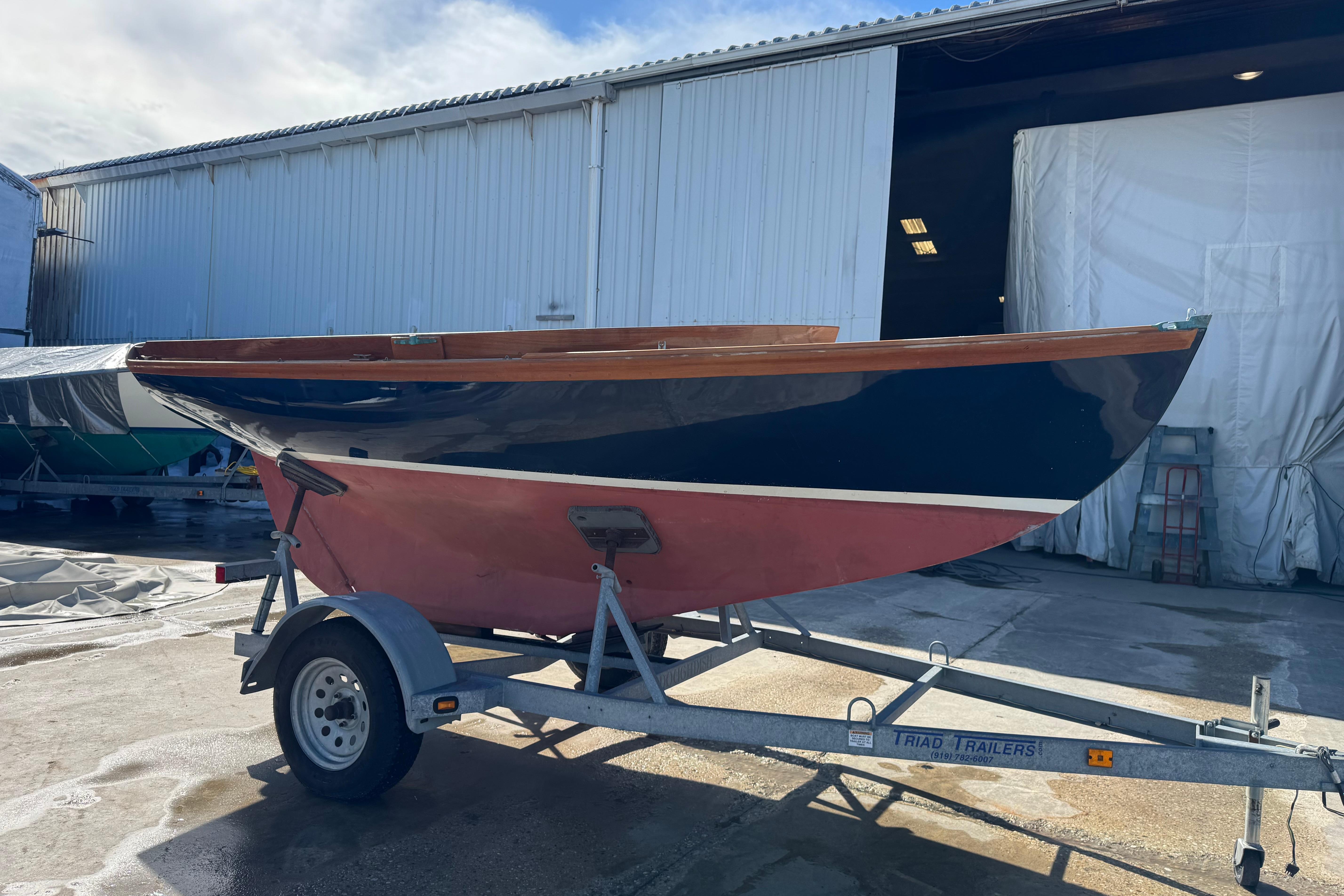 2018 Ballentine's Boat Shop Doughdish sailboat on trailer outside a warehouse.