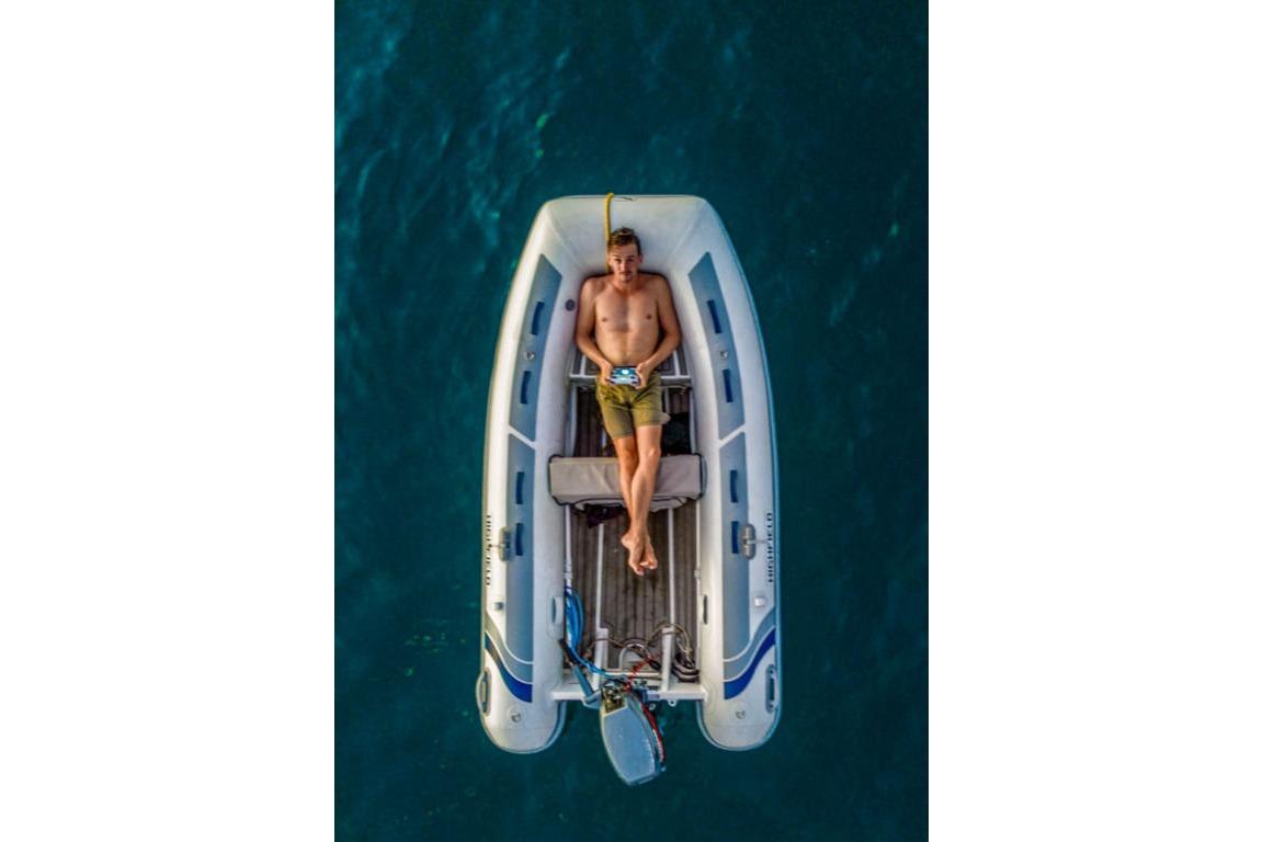Man relaxing on a 2025 Highfield Classic 310 boat in open water.