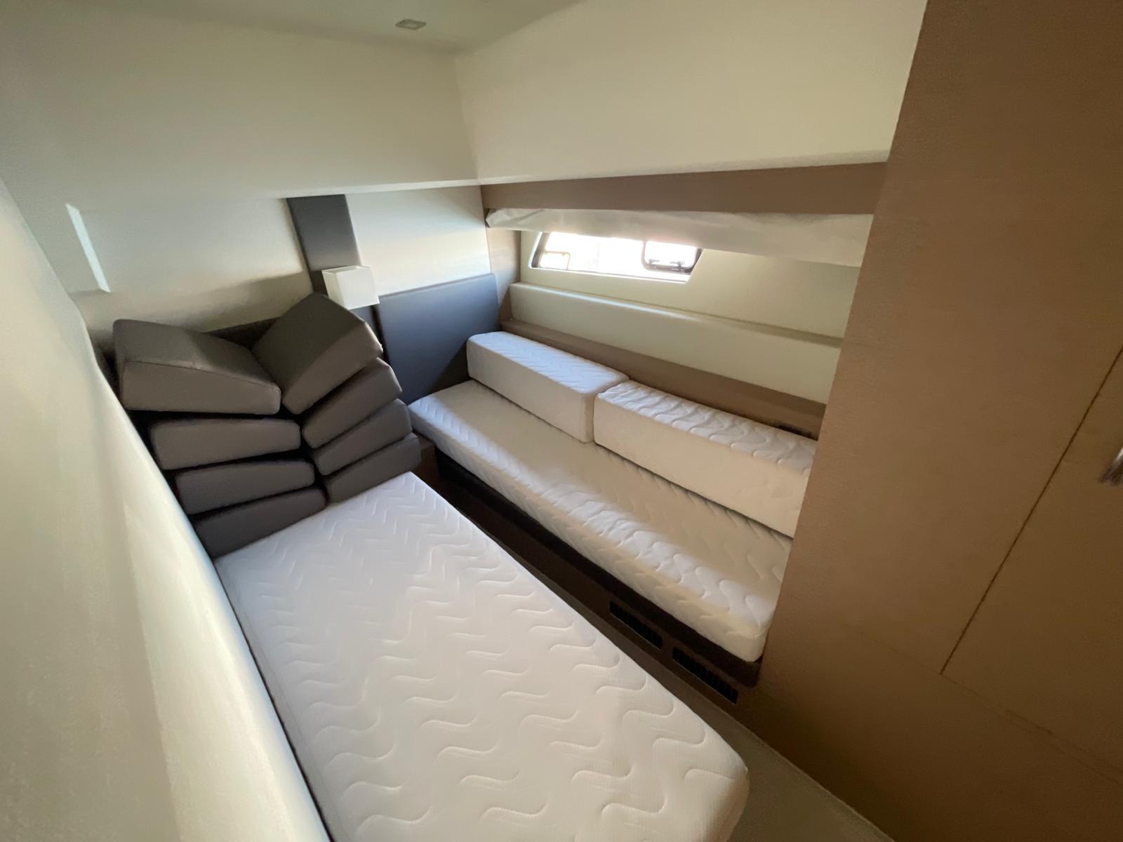 Interior cabin of 2018 Prestige 560 yacht with stacked cushions and mattresses.