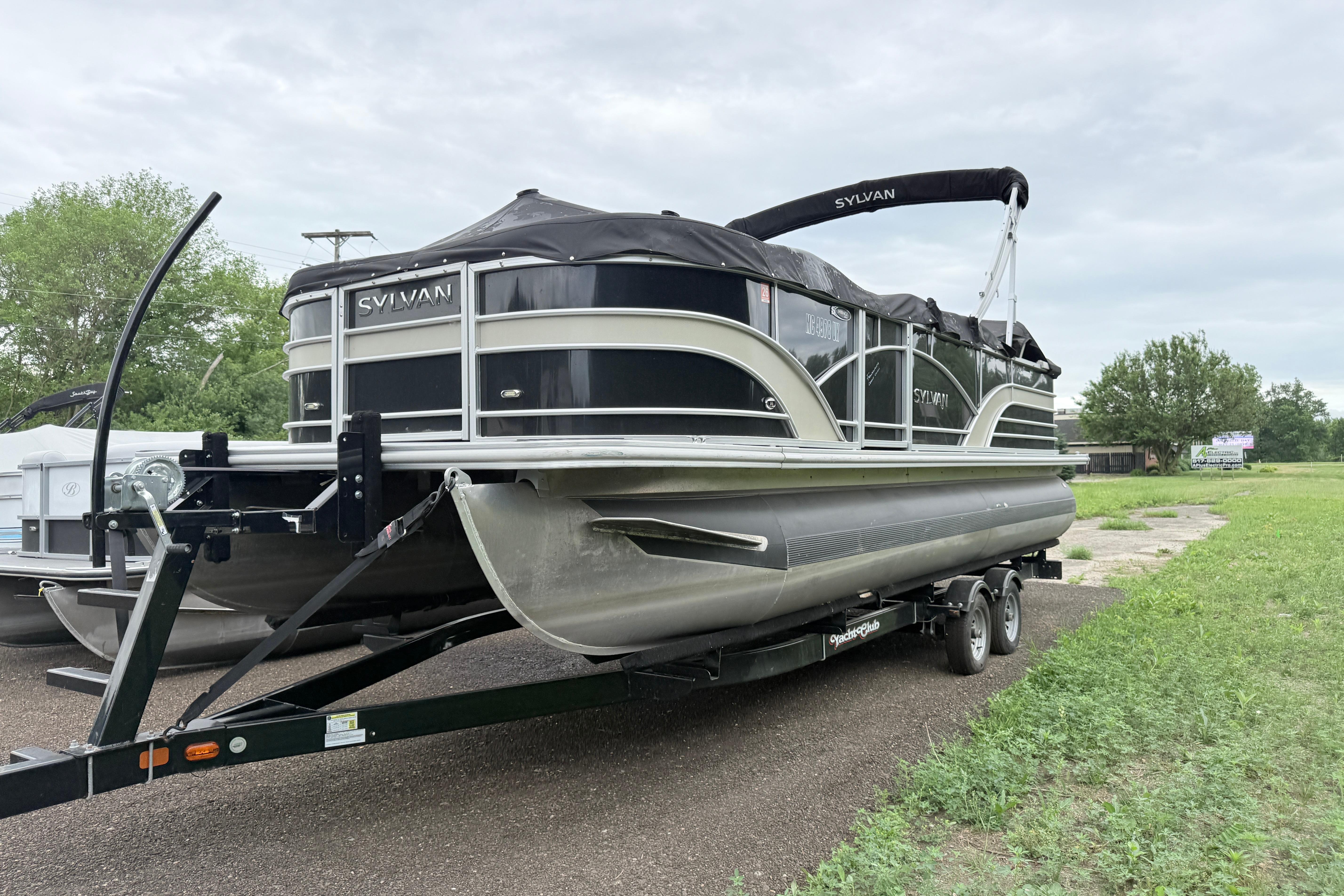 2019 Sylvan 8522 Mirage Signature pontoon boat on trailer, parked outdoors.