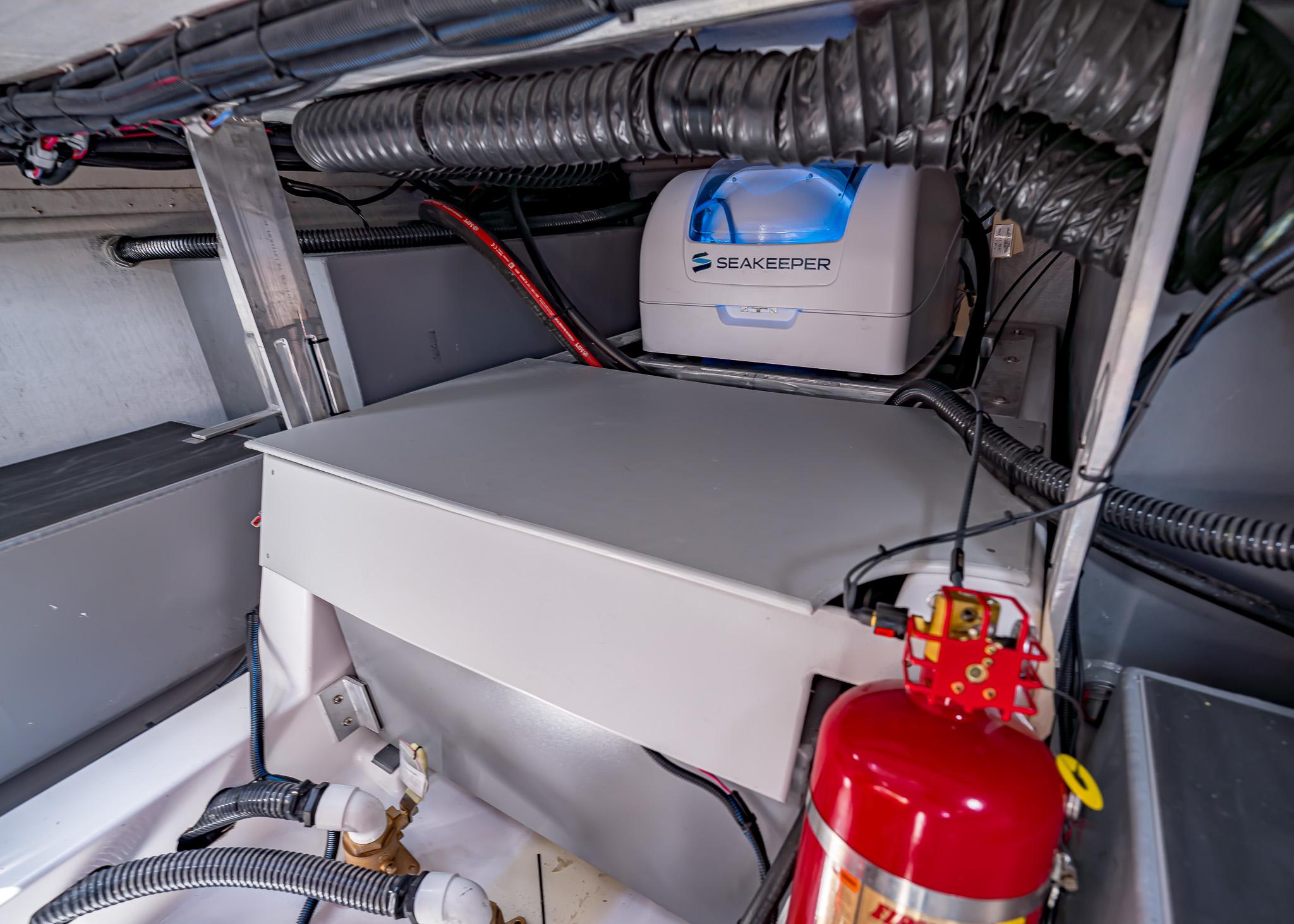 Engine compartment of 2025 Paradigm Damascus 266 Surf with Seakeeper stabilizer and fire extinguisher.