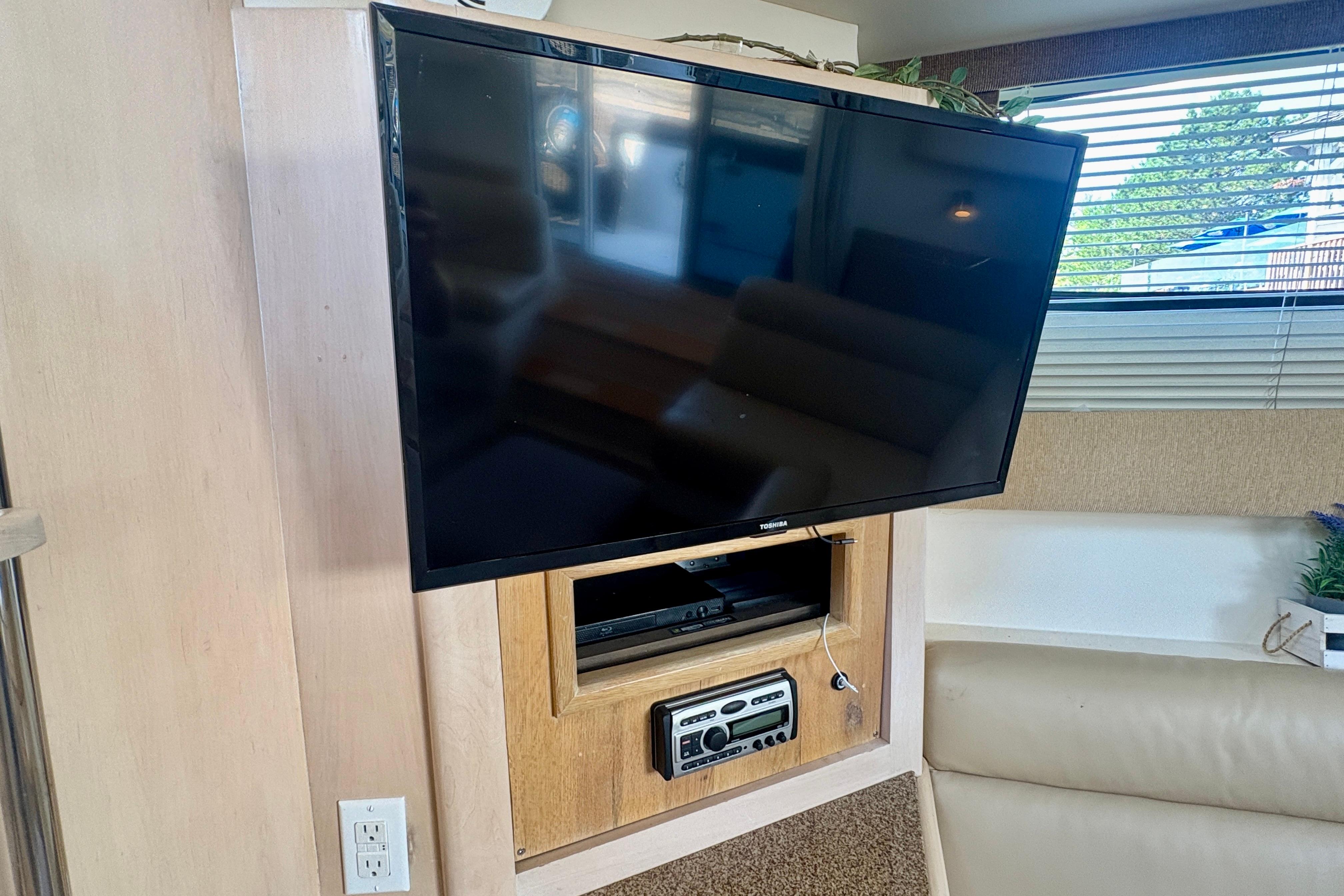 Entertainment setup inside 1999 Carver 350 Mariner yacht with TV and audio system.