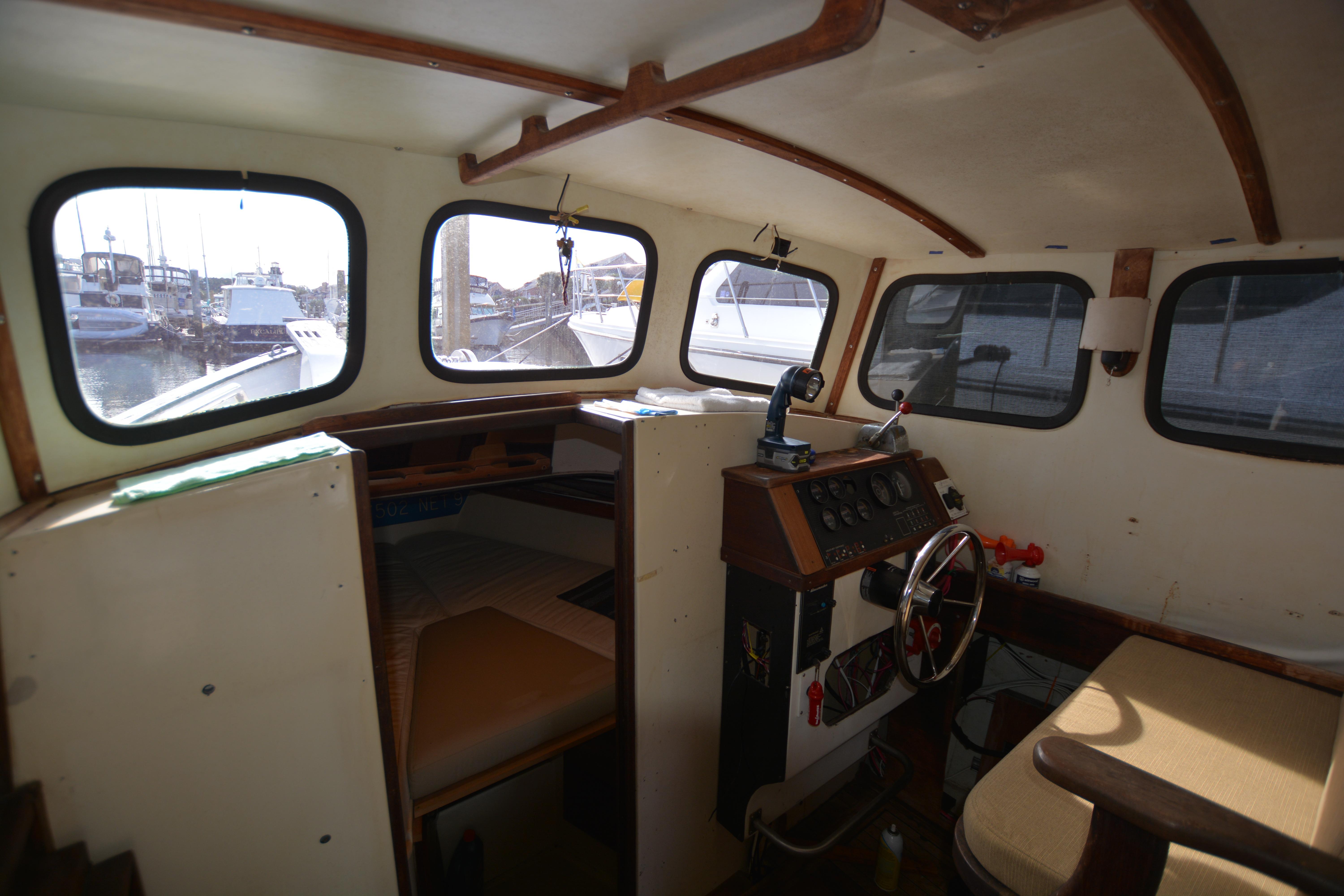 1974 Fales Navigator boat interior with steering wheel and dashboard, docked at marina.