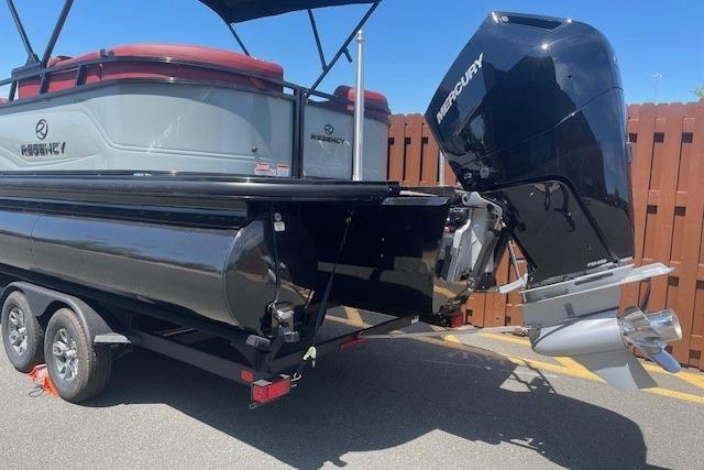 2026 Regency 250 DL pontoon boat with Mercury outboard motor, parked on a trailer.