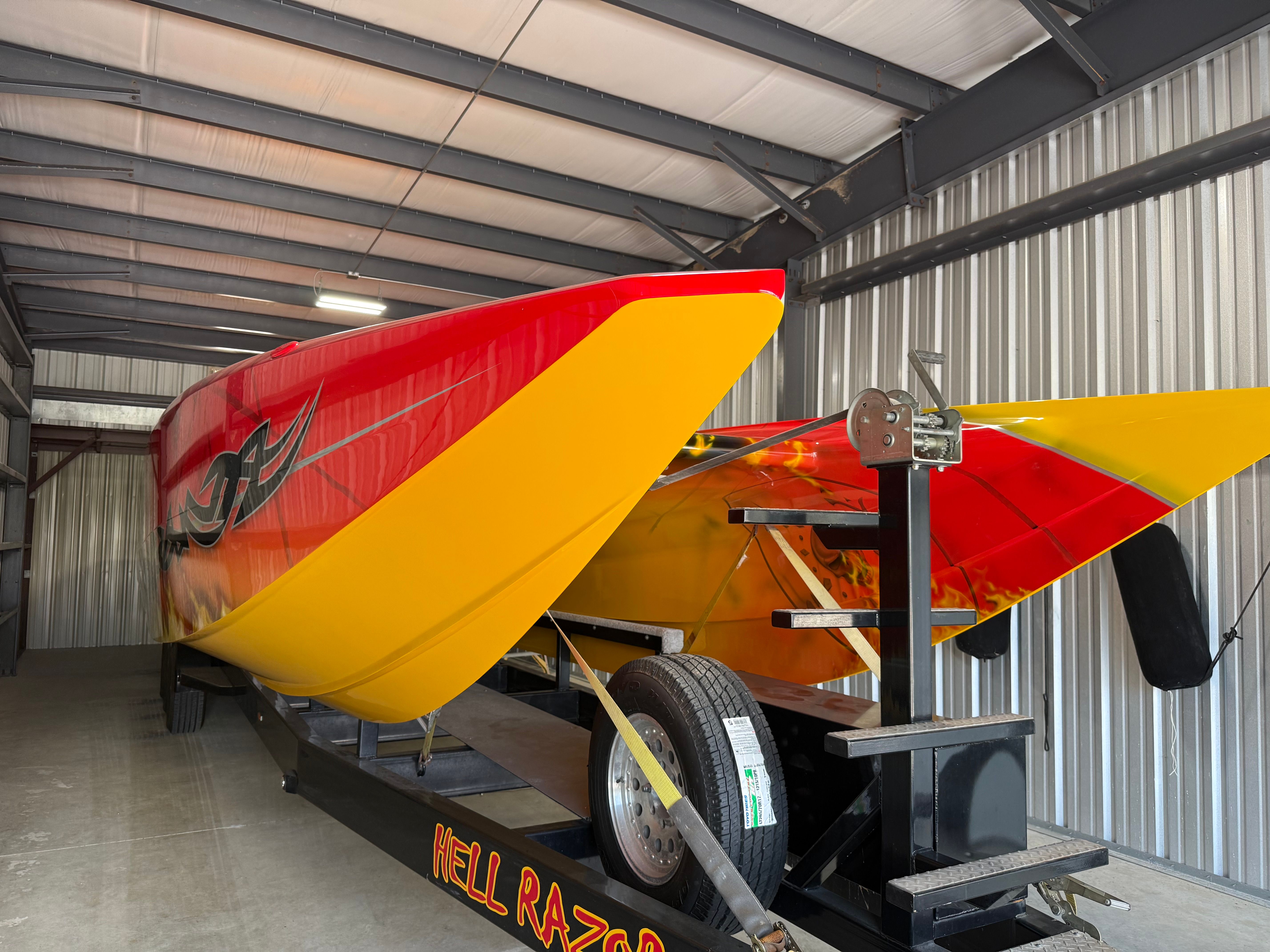 A 2010 MTI CAT in a storage facility. The boat features a striking red and yellow design.
