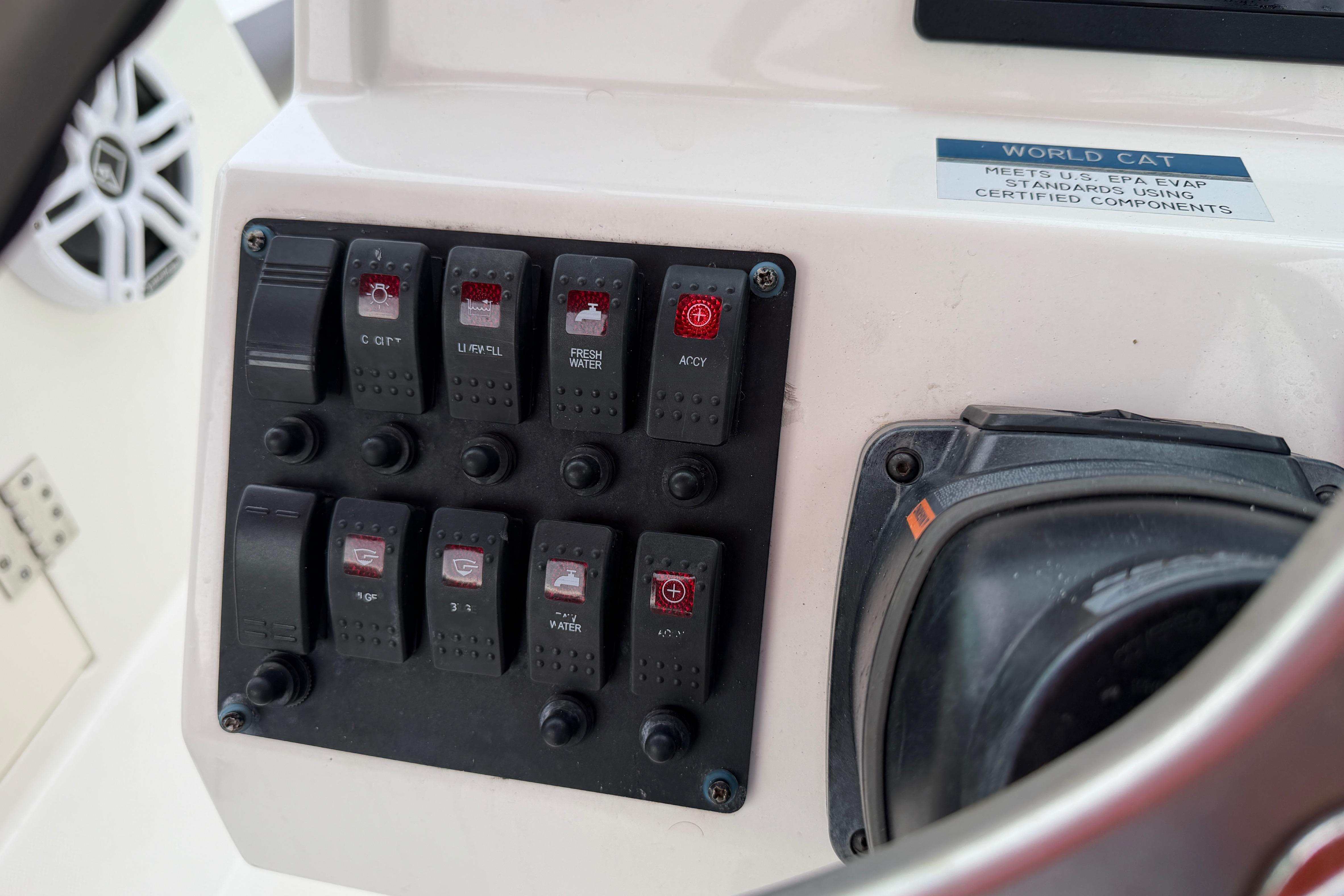 Control panel of a 2019 World Cat 230 DC boat with labeled switches.