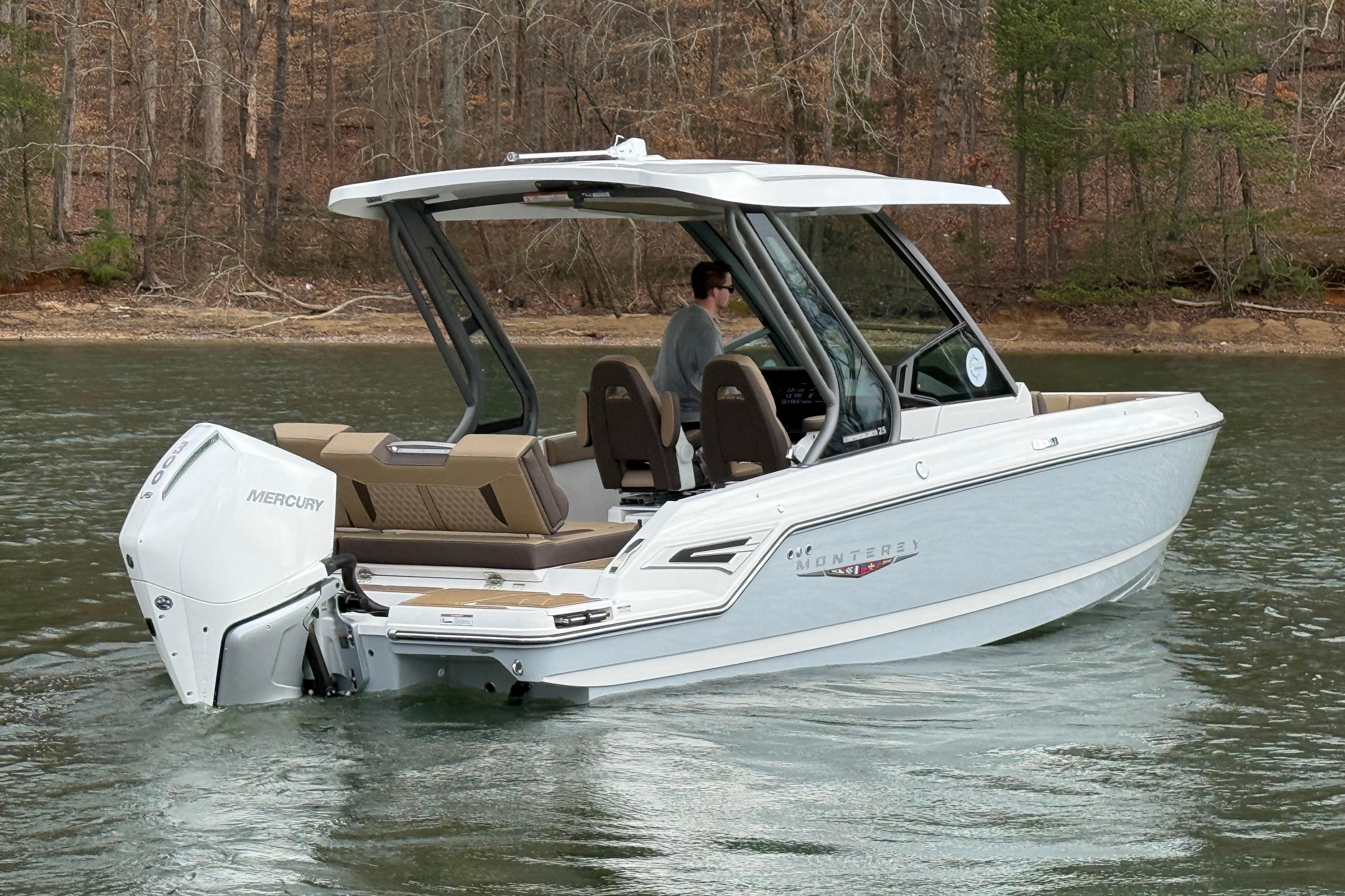 2026 Monterey Elite 25 OB boat cruising on a lake with Mercury outboard engine.