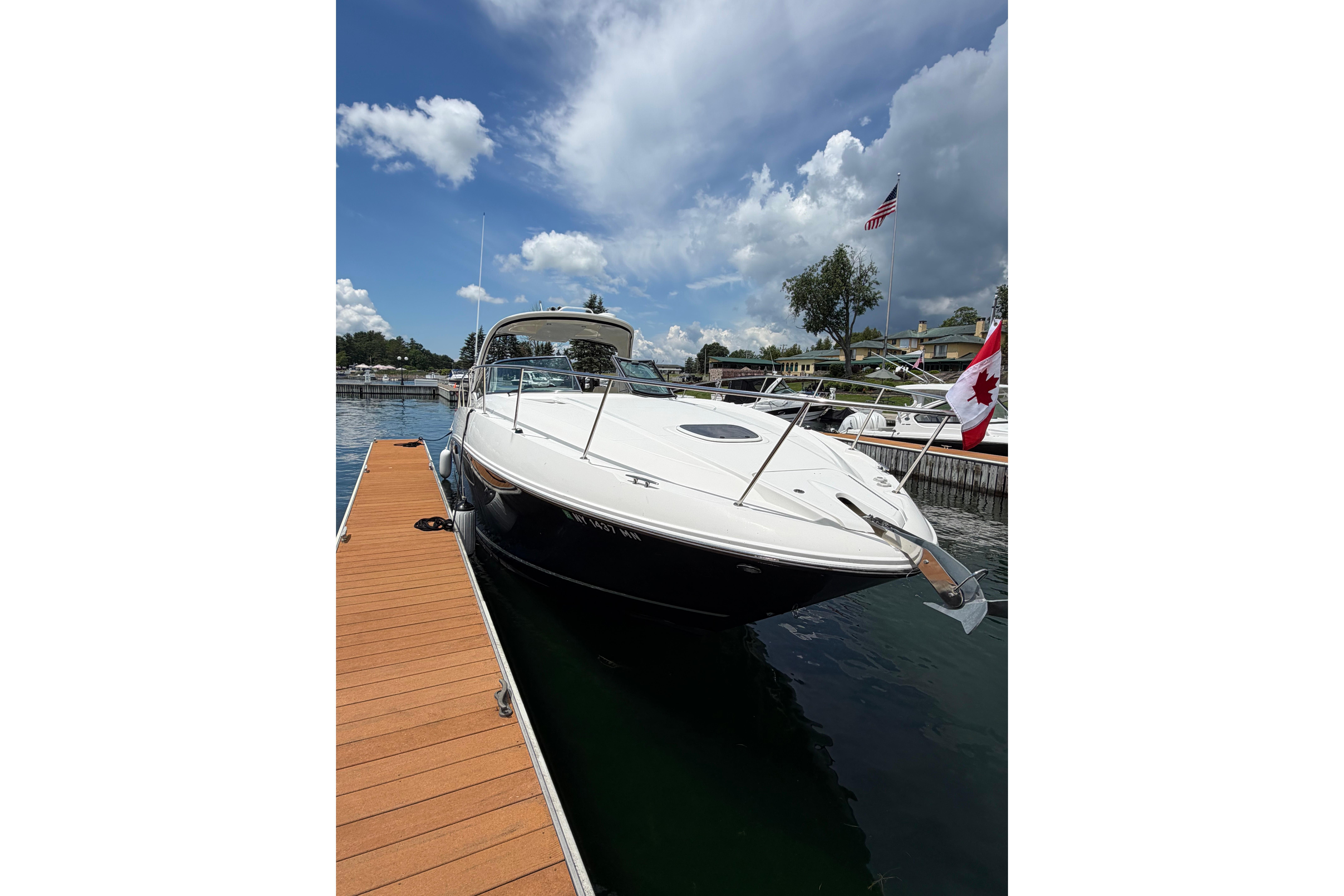 2012 Sea Ray Sundancer 370 docked, featuring sleek design and Canadian flag, under cloudy sky.