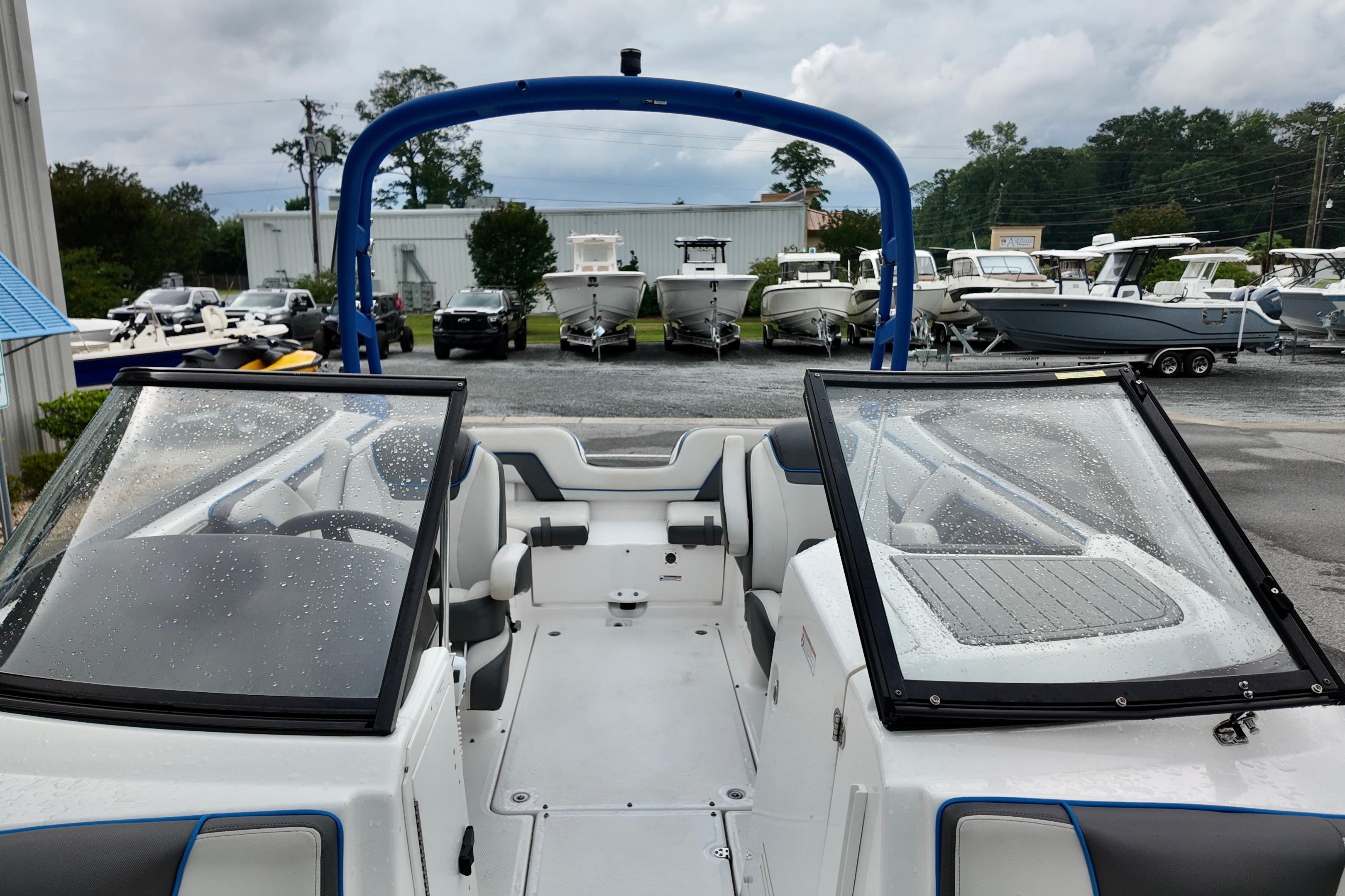 2020 Yamaha Boats AR240 with wet windshield, parked among other boats at a dealership.