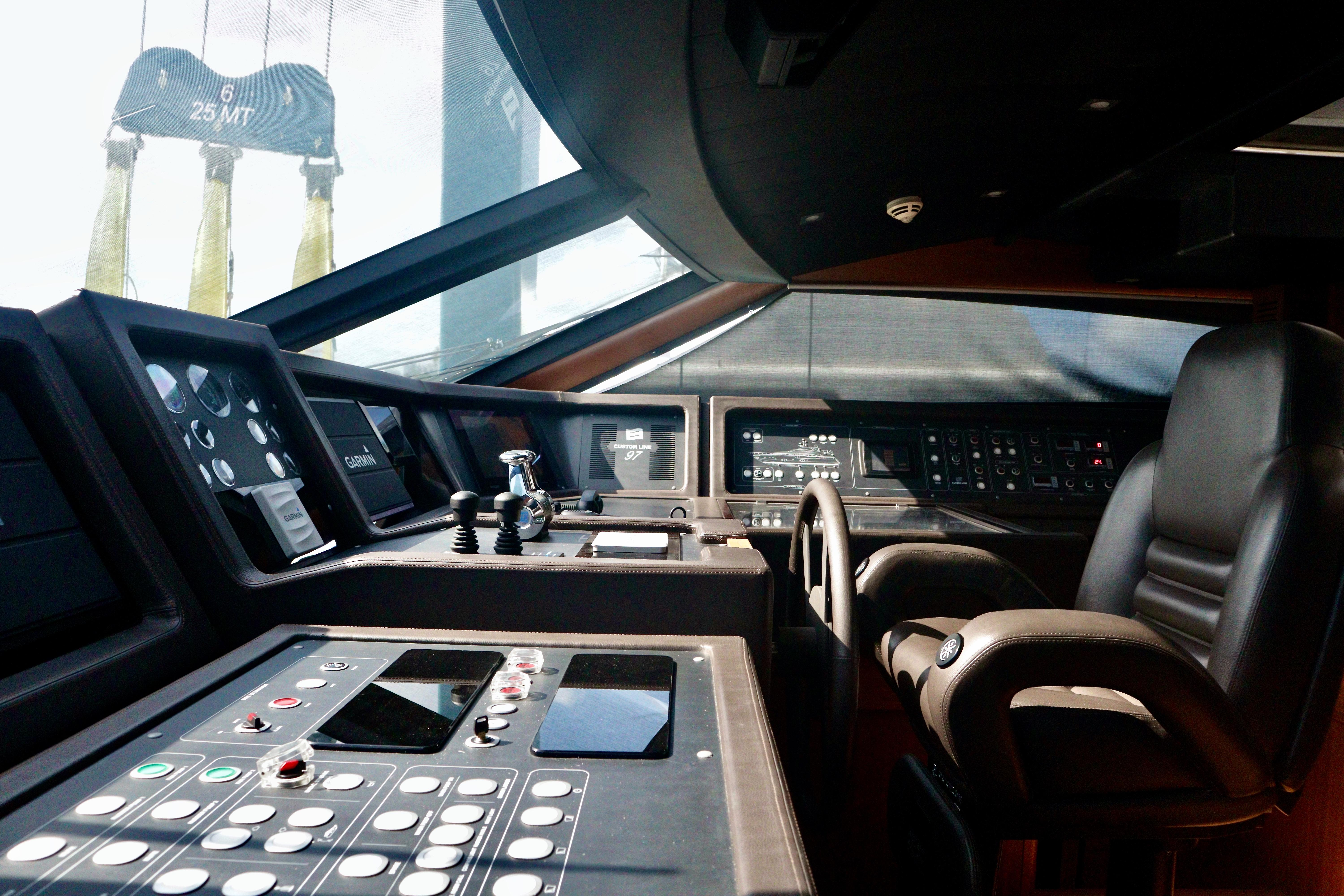 Pilothouse of 2016 Custom Line 97 yacht with advanced navigation controls and leather seating.